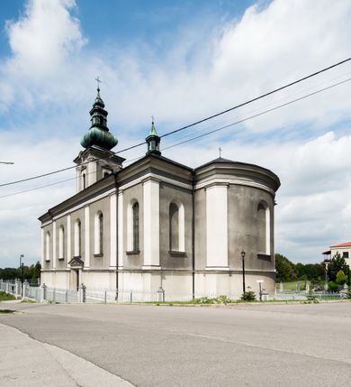 Zdjęcie nr 9: Orientowany kościół pw. Wszystkich Świętych w Wieprzu został wzniesiony w układzie trójnawowej hali z prostokątnym prezbiterium zamkniętym płaską apsydą na przedłużeniu nawy głównej, flankowanego od południa kaplicą, a od północy piętrową zakrystią. Od zachodu do trójprzęsłowego korpusu nawowego dostawiono nieznacznie wysuniętą do przodu czworoboczną wieżę, flankowaną po bokach dwoma aneksami tej samej wysokości, co nawa i aneksy przy prezbiterium. Całość nakryto miedzianym dachem siodłowym. Przy końcu nawy od wschodu na dachu nadwieszono sygnaturkę w formie latarni zwieńczonej ostrosłupowym hełmem. Elewacje zewnętrzne przeprute półokrągłymi oknami artykułowano za pomocą pilastrów o prostych głowicach wspartych na wysoki cokołach połączonych ze sobą gzymsem, podtrzymujących fazowane belkowanie przechodzące w profilowany gzyms koronujący. Elewacje wieży podzielona na dwie strefy rozdzielone belkowaniem wyłamanym w partii masywu wieżowego. W dolnej strefie w przyziemiu urządzono kruchtę, do której wejście na osi flankowane jest masywnym portalem utworzonym z dwóch czworobocznych podpór wspierających trójkątny przyczółek, ponad którym przepruto półokrągłe okno. Ponad gzymsem, w górnej strefie, zastosowano podział ramowy, ujmujący okulus, który pełni partię cokołową wspierającą flankujące górną część wieży pary pilastrów na każdej z czterech elewacji. Pilastry ustawione na postumentach o gładkich trzonach i kompozytowych głowicach wspierają fazowane belkowanie przechodzące w gzyms koronujący. Pomiędzy pilastrami przepruto półokrągłe okna z umieszczonymi nad nimi trójkątnymi przyczółkami. Gzyms został wyłamany na każdej z osi środkowej, tworząc miejsce dla tarcz zegarowych. Wieżę zwieńczono baniastym hełmem z czworoboczną latarnią nakrytą cebulastym zwieńczeniem z krzyżem. Nawa główna otwiera się do naw bocznych z każdej strony otwiera się do naw bocznych z każdej strony trzema opilastrowanymi arkadami filarowymi. Wnętrze nakryto sklepieniem krzyżowym. Chór muzyczny zajmuje szerokość całego korpusu nawowego, wspierając się na pięciu arkadach - trzy w nawie głównej i po jednej w nawach bocznych. Balustrada na chórze artykułowana jest płycinami rozdzielonymi niskim postumentami. W prezbiterium ustawiono ołtarz główny, a na zakończeniu naw ołtarze boczne. Dwa ołtarze boczne znalazły się także w części zachodniej nawy południowej i północnej.