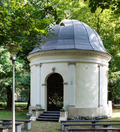 Zdjęcie nr 1: Kaplicę wzniesiono na rzucie koła, nakrywając jej wnętrze półkolistą kopułą. Ściany zewnętrzne zostały podzielone ośmioma pilastrami jońskimi, wspierającymi belkowanie. Powyżej belkowania biegnie profilowany gzyms koronujący, dekorowany fryzem kostkowym. Półokrągłe wejście usytuowano od zachodu. Prowadzi do niego pięć stopni. Wejście zamyka żelazna, klasycystyczna krata. Od wschodu w ścianie przepruto okulus, ujęty od wnętrza półokrągłym glifem w płytkiej, prostokątnej niszy zamkniętej półokrągło. Wnętrze pokryto ochrową polichromią, z wymalowanym białą kreską podziałem odzwierciedlającym artykulację zewnętrzną. Na ścianie umieszczono dwie czworoboczne płyty upamiętniające zmarłych pochowanych w krypcie. Wejście do krypty zamyka prostokątna, marmurowa płyta dekorowana aplikacją ze złoconego brązu, ukazującą trupią czaszkę ze skrzyżowanymi piszczelami umieszczoną nad antabą.