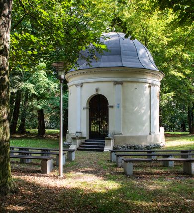 Zdjęcie nr 2: Kaplicę wzniesiono na rzucie koła, nakrywając jej wnętrze półkolistą kopułą. Ściany zewnętrzne zostały podzielone ośmioma pilastrami jońskimi, wspierającymi belkowanie. Powyżej belkowania biegnie profilowany gzyms koronujący, dekorowany fryzem kostkowym. Półokrągłe wejście usytuowano od zachodu. Prowadzi do niego pięć stopni. Wejście zamyka żelazna, klasycystyczna krata. Od wschodu w ścianie przepruto okulus, ujęty od wnętrza półokrągłym glifem w płytkiej, prostokątnej niszy zamkniętej półokrągło. Wnętrze pokryto ochrową polichromią, z wymalowanym białą kreską podziałem odzwierciedlającym artykulację zewnętrzną. Na ścianie umieszczono dwie czworoboczne płyty upamiętniające zmarłych pochowanych w krypcie. Wejście do krypty zamyka prostokątna, marmurowa płyta dekorowana aplikacją ze złoconego brązu, ukazującą trupią czaszkę ze skrzyżowanymi piszczelami umieszczoną nad antabą.