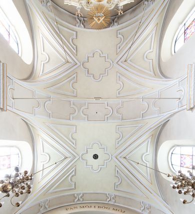 Zdjęcie nr 39: Kościół Wniebowzięcia Najświętszej Marii Panny w Oświęcimu jest świątynia murowaną, orientowaną. Dwuprzęsłowe prezbiterium zamknięte ścianą prostą wzniesiono na rzucie prostokąta. W jego narożach widoczne są przypory. Od południa wybudowano przy nim zakrystię, a od północy kaplicę Chrystusa Ukrzyżowanego, którą gruntownie przebudowano w stylu pseudoromańskim w latach dwudziestych XX wieku. Korpus kościoła uzyskał układ trójnawowej, dwuprzęsłowej hali. Od zachodu na osi wzniesiono czworoboczną, dwupoziomową wieżę. Pierwszy poziom, w którym urządzono kruchtę, jest zaopatrzony w narożach w uskokowe przypory. Natomiast drugi, wyraźnie zmniejszony, został wzniesiony ponad profilowanym gzymsem na rzucie czworobocznym o ściętych narożach. Całość nakryto ostrosłupowym hełmem zwieńczonym krzyżem, wspartym na trójkątnych przyczółkach stanowiących zakończenie ścian drugiego poziomu. Nawa główna otwiera się do naw bocznych z każdej strony poprzez dwiema opilastrowanymi arkadami filarowymi. Tęcza pomiędzy nawą, a prezbiterium uzyskała wykrój półkolisty. Wnetrze obu części kościoła nakryto sklepieniem kolebkowym z lunetami wsparte na gurtach. W części zachodniej kościoła na długości całego korpusu urządzono chór muzyczny wsparty na trzech arkadach z parapetem wygiętym łukowo pośrodku. Sklepienie i parapet chóru zostały udekorowane figurami geometrycznymi ze stiukowych listw profilowanych. Do południowej nawy bocznej prowadzi gotycki, ostrołukowy portal kamienny. Z kolei wejście do prezbiterium z zakrystii oraz z kruchty do północnej nawy bocznej obramieniają dwa prostokątne, kamienne portale gotycko-renesansowe. W prezbiterium ustawiono ołtarz główny, a dwa ołtarze boczne na wschodniej ścianie naw bocznych. Kolejny ołtarz boczny znalazł się po prawej stronie łuku tęczowego. Po jego zaś drugiej stronie zawieszono ambonę. 