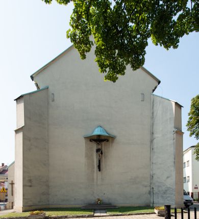 Zdjęcie nr 11: Kościół Wniebowzięcia Najświętszej Marii Panny w Oświęcimu jest świątynia murowaną, orientowaną. Dwuprzęsłowe prezbiterium zamknięte ścianą prostą wzniesiono na rzucie prostokąta. W jego narożach widoczne są przypory. Od południa wybudowano przy nim zakrystię, a od północy kaplicę Chrystusa Ukrzyżowanego, którą gruntownie przebudowano w stylu pseudoromańskim w latach dwudziestych XX wieku. Korpus kościoła uzyskał układ trójnawowej, dwuprzęsłowej hali. Od zachodu na osi wzniesiono czworoboczną, dwupoziomową wieżę. Pierwszy poziom, w którym urządzono kruchtę, jest zaopatrzony w narożach w uskokowe przypory. Natomiast drugi, wyraźnie zmniejszony, został wzniesiony ponad profilowanym gzymsem na rzucie czworobocznym o ściętych narożach. Całość nakryto ostrosłupowym hełmem zwieńczonym krzyżem, wspartym na trójkątnych przyczółkach stanowiących zakończenie ścian drugiego poziomu. Nawa główna otwiera się do naw bocznych z każdej strony poprzez dwiema opilastrowanymi arkadami filarowymi. Tęcza pomiędzy nawą, a prezbiterium uzyskała wykrój półkolisty. Wnetrze obu części kościoła nakryto sklepieniem kolebkowym z lunetami wsparte na gurtach. W części zachodniej kościoła na długości całego korpusu urządzono chór muzyczny wsparty na trzech arkadach z parapetem wygiętym łukowo pośrodku. Sklepienie i parapet chóru zostały udekorowane figurami geometrycznymi ze stiukowych listw profilowanych. Do południowej nawy bocznej prowadzi gotycki, ostrołukowy portal kamienny. Z kolei wejście do prezbiterium z zakrystii oraz z kruchty do północnej nawy bocznej obramieniają dwa prostokątne, kamienne portale gotycko-renesansowe. W prezbiterium ustawiono ołtarz główny, a dwa ołtarze boczne na wschodniej ścianie naw bocznych. Kolejny ołtarz boczny znalazł się po prawej stronie łuku tęczowego. Po jego zaś drugiej stronie zawieszono ambonę. 