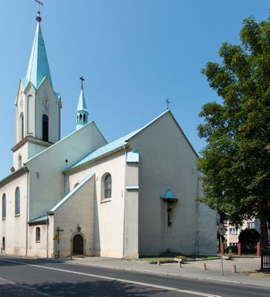 Zdjęcie nr 7: Kościół Wniebowzięcia Najświętszej Marii Panny w Oświęcimu jest świątynia murowaną, orientowaną. Dwuprzęsłowe prezbiterium zamknięte ścianą prostą wzniesiono na rzucie prostokąta. W jego narożach widoczne są przypory. Od południa wybudowano przy nim zakrystię, a od północy kaplicę Chrystusa Ukrzyżowanego, którą gruntownie przebudowano w stylu pseudoromańskim w latach dwudziestych XX wieku. Korpus kościoła uzyskał układ trójnawowej, dwuprzęsłowej hali. Od zachodu na osi wzniesiono czworoboczną, dwupoziomową wieżę. Pierwszy poziom, w którym urządzono kruchtę, jest zaopatrzony w narożach w uskokowe przypory. Natomiast drugi, wyraźnie zmniejszony, został wzniesiony ponad profilowanym gzymsem na rzucie czworobocznym o ściętych narożach. Całość nakryto ostrosłupowym hełmem zwieńczonym krzyżem, wspartym na trójkątnych przyczółkach stanowiących zakończenie ścian drugiego poziomu. Nawa główna otwiera się do naw bocznych z każdej strony poprzez dwiema opilastrowanymi arkadami filarowymi. Tęcza pomiędzy nawą, a prezbiterium uzyskała wykrój półkolisty. Wnetrze obu części kościoła nakryto sklepieniem kolebkowym z lunetami wsparte na gurtach. W części zachodniej kościoła na długości całego korpusu urządzono chór muzyczny wsparty na trzech arkadach z parapetem wygiętym łukowo pośrodku. Sklepienie i parapet chóru zostały udekorowane figurami geometrycznymi ze stiukowych listw profilowanych. Do południowej nawy bocznej prowadzi gotycki, ostrołukowy portal kamienny. Z kolei wejście do prezbiterium z zakrystii oraz z kruchty do północnej nawy bocznej obramieniają dwa prostokątne, kamienne portale gotycko-renesansowe. W prezbiterium ustawiono ołtarz główny, a dwa ołtarze boczne na wschodniej ścianie naw bocznych. Kolejny ołtarz boczny znalazł się po prawej stronie łuku tęczowego. Po jego zaś drugiej stronie zawieszono ambonę. 