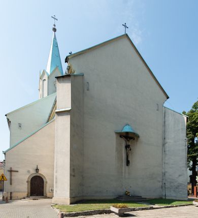 Zdjęcie nr 12: Kościół Wniebowzięcia Najświętszej Marii Panny w Oświęcimu jest świątynia murowaną, orientowaną. Dwuprzęsłowe prezbiterium zamknięte ścianą prostą wzniesiono na rzucie prostokąta. W jego narożach widoczne są przypory. Od południa wybudowano przy nim zakrystię, a od północy kaplicę Chrystusa Ukrzyżowanego, którą gruntownie przebudowano w stylu pseudoromańskim w latach dwudziestych XX wieku. Korpus kościoła uzyskał układ trójnawowej, dwuprzęsłowej hali. Od zachodu na osi wzniesiono czworoboczną, dwupoziomową wieżę. Pierwszy poziom, w którym urządzono kruchtę, jest zaopatrzony w narożach w uskokowe przypory. Natomiast drugi, wyraźnie zmniejszony, został wzniesiony ponad profilowanym gzymsem na rzucie czworobocznym o ściętych narożach. Całość nakryto ostrosłupowym hełmem zwieńczonym krzyżem, wspartym na trójkątnych przyczółkach stanowiących zakończenie ścian drugiego poziomu. Nawa główna otwiera się do naw bocznych z każdej strony poprzez dwiema opilastrowanymi arkadami filarowymi. Tęcza pomiędzy nawą, a prezbiterium uzyskała wykrój półkolisty. Wnetrze obu części kościoła nakryto sklepieniem kolebkowym z lunetami wsparte na gurtach. W części zachodniej kościoła na długości całego korpusu urządzono chór muzyczny wsparty na trzech arkadach z parapetem wygiętym łukowo pośrodku. Sklepienie i parapet chóru zostały udekorowane figurami geometrycznymi ze stiukowych listw profilowanych. Do południowej nawy bocznej prowadzi gotycki, ostrołukowy portal kamienny. Z kolei wejście do prezbiterium z zakrystii oraz z kruchty do północnej nawy bocznej obramieniają dwa prostokątne, kamienne portale gotycko-renesansowe. W prezbiterium ustawiono ołtarz główny, a dwa ołtarze boczne na wschodniej ścianie naw bocznych. Kolejny ołtarz boczny znalazł się po prawej stronie łuku tęczowego. Po jego zaś drugiej stronie zawieszono ambonę. 