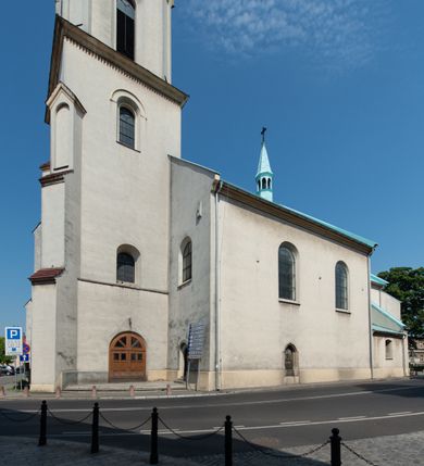 Zdjęcie nr 4: Kościół Wniebowzięcia Najświętszej Marii Panny w Oświęcimu jest świątynia murowaną, orientowaną. Dwuprzęsłowe prezbiterium zamknięte ścianą prostą wzniesiono na rzucie prostokąta. W jego narożach widoczne są przypory. Od południa wybudowano przy nim zakrystię, a od północy kaplicę Chrystusa Ukrzyżowanego, którą gruntownie przebudowano w stylu pseudoromańskim w latach dwudziestych XX wieku. Korpus kościoła uzyskał układ trójnawowej, dwuprzęsłowej hali. Od zachodu na osi wzniesiono czworoboczną, dwupoziomową wieżę. Pierwszy poziom, w którym urządzono kruchtę, jest zaopatrzony w narożach w uskokowe przypory. Natomiast drugi, wyraźnie zmniejszony, został wzniesiony ponad profilowanym gzymsem na rzucie czworobocznym o ściętych narożach. Całość nakryto ostrosłupowym hełmem zwieńczonym krzyżem, wspartym na trójkątnych przyczółkach stanowiących zakończenie ścian drugiego poziomu. Nawa główna otwiera się do naw bocznych z każdej strony poprzez dwiema opilastrowanymi arkadami filarowymi. Tęcza pomiędzy nawą, a prezbiterium uzyskała wykrój półkolisty. Wnetrze obu części kościoła nakryto sklepieniem kolebkowym z lunetami wsparte na gurtach. W części zachodniej kościoła na długości całego korpusu urządzono chór muzyczny wsparty na trzech arkadach z parapetem wygiętym łukowo pośrodku. Sklepienie i parapet chóru zostały udekorowane figurami geometrycznymi ze stiukowych listw profilowanych. Do południowej nawy bocznej prowadzi gotycki, ostrołukowy portal kamienny. Z kolei wejście do prezbiterium z zakrystii oraz z kruchty do północnej nawy bocznej obramieniają dwa prostokątne, kamienne portale gotycko-renesansowe. W prezbiterium ustawiono ołtarz główny, a dwa ołtarze boczne na wschodniej ścianie naw bocznych. Kolejny ołtarz boczny znalazł się po prawej stronie łuku tęczowego. Po jego zaś drugiej stronie zawieszono ambonę. 
