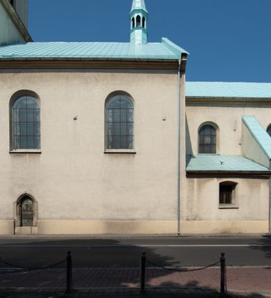 Zdjęcie nr 45: Kościół Wniebowzięcia Najświętszej Marii Panny w Oświęcimu jest świątynia murowaną, orientowaną. Dwuprzęsłowe prezbiterium zamknięte ścianą prostą wzniesiono na rzucie prostokąta. W jego narożach widoczne są przypory. Od południa wybudowano przy nim zakrystię, a od północy kaplicę Chrystusa Ukrzyżowanego, którą gruntownie przebudowano w stylu pseudoromańskim w latach dwudziestych XX wieku. Korpus kościoła uzyskał układ trójnawowej, dwuprzęsłowej hali. Od zachodu na osi wzniesiono czworoboczną, dwupoziomową wieżę. Pierwszy poziom, w którym urządzono kruchtę, jest zaopatrzony w narożach w uskokowe przypory. Natomiast drugi, wyraźnie zmniejszony, został wzniesiony ponad profilowanym gzymsem na rzucie czworobocznym o ściętych narożach. Całość nakryto ostrosłupowym hełmem zwieńczonym krzyżem, wspartym na trójkątnych przyczółkach stanowiących zakończenie ścian drugiego poziomu. Nawa główna otwiera się do naw bocznych z każdej strony poprzez dwiema opilastrowanymi arkadami filarowymi. Tęcza pomiędzy nawą, a prezbiterium uzyskała wykrój półkolisty. Wnetrze obu części kościoła nakryto sklepieniem kolebkowym z lunetami wsparte na gurtach. W części zachodniej kościoła na długości całego korpusu urządzono chór muzyczny wsparty na trzech arkadach z parapetem wygiętym łukowo pośrodku. Sklepienie i parapet chóru zostały udekorowane figurami geometrycznymi ze stiukowych listw profilowanych. Do południowej nawy bocznej prowadzi gotycki, ostrołukowy portal kamienny. Z kolei wejście do prezbiterium z zakrystii oraz z kruchty do północnej nawy bocznej obramieniają dwa prostokątne, kamienne portale gotycko-renesansowe. W prezbiterium ustawiono ołtarz główny, a dwa ołtarze boczne na wschodniej ścianie naw bocznych. Kolejny ołtarz boczny znalazł się po prawej stronie łuku tęczowego. Po jego zaś drugiej stronie zawieszono ambonę. 