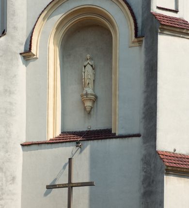 Zdjęcie nr 44: Kościół Wniebowzięcia Najświętszej Marii Panny w Oświęcimu jest świątynia murowaną, orientowaną. Dwuprzęsłowe prezbiterium zamknięte ścianą prostą wzniesiono na rzucie prostokąta. W jego narożach widoczne są przypory. Od południa wybudowano przy nim zakrystię, a od północy kaplicę Chrystusa Ukrzyżowanego, którą gruntownie przebudowano w stylu pseudoromańskim w latach dwudziestych XX wieku. Korpus kościoła uzyskał układ trójnawowej, dwuprzęsłowej hali. Od zachodu na osi wzniesiono czworoboczną, dwupoziomową wieżę. Pierwszy poziom, w którym urządzono kruchtę, jest zaopatrzony w narożach w uskokowe przypory. Natomiast drugi, wyraźnie zmniejszony, został wzniesiony ponad profilowanym gzymsem na rzucie czworobocznym o ściętych narożach. Całość nakryto ostrosłupowym hełmem zwieńczonym krzyżem, wspartym na trójkątnych przyczółkach stanowiących zakończenie ścian drugiego poziomu. Nawa główna otwiera się do naw bocznych z każdej strony poprzez dwiema opilastrowanymi arkadami filarowymi. Tęcza pomiędzy nawą, a prezbiterium uzyskała wykrój półkolisty. Wnetrze obu części kościoła nakryto sklepieniem kolebkowym z lunetami wsparte na gurtach. W części zachodniej kościoła na długości całego korpusu urządzono chór muzyczny wsparty na trzech arkadach z parapetem wygiętym łukowo pośrodku. Sklepienie i parapet chóru zostały udekorowane figurami geometrycznymi ze stiukowych listw profilowanych. Do południowej nawy bocznej prowadzi gotycki, ostrołukowy portal kamienny. Z kolei wejście do prezbiterium z zakrystii oraz z kruchty do północnej nawy bocznej obramieniają dwa prostokątne, kamienne portale gotycko-renesansowe. W prezbiterium ustawiono ołtarz główny, a dwa ołtarze boczne na wschodniej ścianie naw bocznych. Kolejny ołtarz boczny znalazł się po prawej stronie łuku tęczowego. Po jego zaś drugiej stronie zawieszono ambonę. 