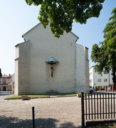 Zdjęcie nr 48: Kościół Wniebowzięcia Najświętszej Marii Panny w Oświęcimu jest świątynia murowaną, orientowaną. Dwuprzęsłowe prezbiterium zamknięte ścianą prostą wzniesiono na rzucie prostokąta. W jego narożach widoczne są przypory. Od południa wybudowano przy nim zakrystię, a od północy kaplicę Chrystusa Ukrzyżowanego, którą gruntownie przebudowano w stylu pseudoromańskim w latach dwudziestych XX wieku. Korpus kościoła uzyskał układ trójnawowej, dwuprzęsłowej hali. Od zachodu na osi wzniesiono czworoboczną, dwupoziomową wieżę. Pierwszy poziom, w którym urządzono kruchtę, jest zaopatrzony w narożach w uskokowe przypory. Natomiast drugi, wyraźnie zmniejszony, został wzniesiony ponad profilowanym gzymsem na rzucie czworobocznym o ściętych narożach. Całość nakryto ostrosłupowym hełmem zwieńczonym krzyżem, wspartym na trójkątnych przyczółkach stanowiących zakończenie ścian drugiego poziomu. Nawa główna otwiera się do naw bocznych z każdej strony poprzez dwiema opilastrowanymi arkadami filarowymi. Tęcza pomiędzy nawą, a prezbiterium uzyskała wykrój półkolisty. Wnetrze obu części kościoła nakryto sklepieniem kolebkowym z lunetami wsparte na gurtach. W części zachodniej kościoła na długości całego korpusu urządzono chór muzyczny wsparty na trzech arkadach z parapetem wygiętym łukowo pośrodku. Sklepienie i parapet chóru zostały udekorowane figurami geometrycznymi ze stiukowych listw profilowanych. Do południowej nawy bocznej prowadzi gotycki, ostrołukowy portal kamienny. Z kolei wejście do prezbiterium z zakrystii oraz z kruchty do północnej nawy bocznej obramieniają dwa prostokątne, kamienne portale gotycko-renesansowe. W prezbiterium ustawiono ołtarz główny, a dwa ołtarze boczne na wschodniej ścianie naw bocznych. Kolejny ołtarz boczny znalazł się po prawej stronie łuku tęczowego. Po jego zaś drugiej stronie zawieszono ambonę. 