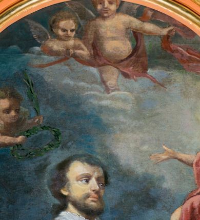 Zdjęcie nr 4: Obraz w kształcie stojącego prostokąta zamkniętego łukiem nadwieszonym z uskokiem. W centrum kompozycji stoi przedstawiony w całej postaci św. Walenty, który spogląda na ukazującego mu się Jezusa, lewą rękę składa na piersi, a prawą wyciąga w geście błogosławieństwa. Ma małą, owalną twarz, z głęboko osadzonymi oczami i małymi ustami otoczonymi wąsami i krótką brodą; włosy krótkie. Jest ubrany w białą albę z pasem koronki na dole i u rękawów i czerwony, lamowany złotem ornat, spod którego wystaje fragment stuły, przez lewą rękę ma przewiązany manipularz. Przed nim, na obłokach tronuje Chrystus ubrany jedynie w czerwony płaszcz. Prawą rękę wyciąga przed siebie, w lewej trzyma widoczny jedynie we fragmencie krzyż, spogląda na świętego. Z lewej strony kompozycji w stronę Walentego zlatuje putto trzymające wieniec z liści laurowych oraz palmę męczeństwa. W łuku zamykającym od góry kompozycję widoczne są dwa kolejne aniołki. U stóp Walentego, na ziemi leży kobieta w białej sukni z owiniętą głową. Jest przykryta czerwonym płaszczem, rękę składa na piersi, ma zamknięte oczy. W tle górzysty krajobraz, powyżej granatowe niebo, rozjaśnione jedynie za postacią Chrystusa. Obraz w złoconej, profilowanej ramie. 