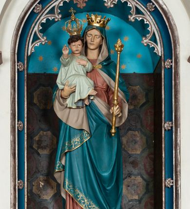 Zdjęcie nr 10: Ołtarz architektoniczny, przyścienny, jednokondygnacyjny, trójosiowy, ze zwieńczeniem. Ołtarz prostopadłościenny z antepedium zdobionym polichromowanym motywem liści akantu po bokach, pośrodku medalion z monogramem chrystologicznym. Tabernakulum w formie prostopadłościennej szafki z drzwiczkami zamkniętymi łukiem półkolistym ujętym fryzem arkadkowym, zdobionych monogramem chrystologicznym. Retabulum na niewysokim, zryzalitowanym cokole o zakończeniach w formie konsoli. Osi głównej części nastawy są w formie półkolistych arkad z niszami, wspartych parami kolumn o kapitelach kompozytowych, przy czym środkowa jest większa względem bocznych dźwigających belkowanie. Zwieńczenie części środkowej retabulum przybiera formę zbliżoną do trójkątnego przyczółka. Pola cokołu retabulum zdobi polichromowana i płaskorzeźbiona ornamentyka roślinna. Ścianki niszy pokryte są dekoracją malarską naśladującą wzorzyste tkaniny, a w górnej partii błękitne, gwieździste niebo. Łuki nisz ujmuje ażurowy fryz arkadkowy, dodatkowo obramienie niszy głównej z motywem rozetek. W przyłuczach dekoracja w formie wici roślinnej. Krawędź attyki oraz zwieńczenia zdobi ażurowa wić roślinna. W polu części środkowej znajduje się figura Madonny z Dzieciątkiem, w arkadzie po prawej stronie ołtarza św. Andrzeja, po lewej św. Piotra. Struktura ołtarza utrzymana jest w kolorach białym, niebieskim, zielonym i jasnoczerwonym, detal architektoniczny i ornamentyka są złocone.        