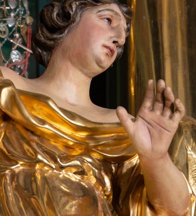 Zdjęcie nr 12: Nastawa architektoniczna, trójosiowa, dwukondygnacyjna, ustawiona na wysokim cokole z wyodrębnionymi prostopadłościanami. Ołtarz prostopadłościenny, z drewnianą mensą. Antepedium ujęte profilowaną ramą, w polu medalion z monogramem IHS w glorii. Na ołtarzu ustawione tabernakulum z tronem wystawienia. Tabernakulum w formie trójosiowej skrzynki, o wklęsło-wypukłym licu, artykułowanej kolumienkami o kręconych trzonach, podtrzymującymi belkowanie, wyłamane na ich osi, z gzymsem wyłamanym faliście na osi środkowej. Drzwiczki w formie stojącego prostokąta zamkniętego łukiem półkolistym nadwieszonym z uskokiem, ujętego ramą z płaskorzeźbionym przedstawieniem kielicha z hostią w glorii. Na osiach bocznych płaskorzeźbione przedstawienia winnego grona. Tron wystawienia w formie paludamentu, podwójnie podwieszonego po bokach, zwieńczonego koroną zamkniętą. 
Cokół dekorowany płycinami wypełnionymi suchym akantem. Pierwsza kondygnacja nastawy ujęta dwiema parami kolumn o kapitelach kompozytowych oraz stojącą między nimi parą pilastrów, w których trzonach znajdują się gabloty na wota. Przed pilastrami na cokołach ustawione dwie figury aniołów. Podpory dźwigają pełne belkowanie, przerwane w partii architrawu i fryzu nad polem środkowym, wyłamane na osi kolumn, na osi pilastrów belkowanie wyłamane pod kątem, w formie impostu z podwieszonymi szyszkami. Na belkowaniu, na obłokach dwie figurki adorujących puttów oraz dwa wazony na cokołach. W polu środkowym wnęka w formie stojącego prostokąta o wciętych górnych narożach, ujęta podwójną ramą, dekorowaną ornamentem roślinnym, z obrazem św. Józefa. Wnęka otoczona z trzech stron gablotami z wotami. Nad nią, w polu belkowania kartusz utworzony z suchego akantu z napisem w polu: „ŚW(IĘTY) JÓZEFIE / MÓDL SIĘ / ZA NAMI”. Druga kondygnacja o szerokości osi środkowej, ustawiona na cokole z wyodrębnionymi prostopadłościanami oraz gablotą z wotami, ujęta dwiema parami pilastrów i spływami wolutowymi oraz stojącą przed nimi parą kolumn, dźwigających zdwojone imposty oraz fragmenty przerwanego, półkolistego przyczółka z siedzącymi puttami. Spływy zdobione festonami utworzonymi z wstęgi oraz kwiatów. Całość zamknięta fragmentem falistego gzymsu oraz Okiem Opatrzności w glorii promienistej. W polu obraz Zaślubin Marii ze św. Józefem w formie stojącego prostokąta o ściętych narożach, ujęty ramą dekorowaną ornamentem roślinnym. Flankowany dwiema prostokątnymi płycinami wypełnionymi akantem. Obie kondygnacje ujęte uszami utworzonymi z suchego akantu. Struktura polichromowana w kolorze zielonym, kolumny, ornamentyka i profile złocone.




