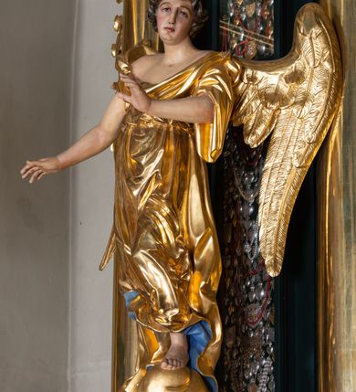 Zdjęcie nr 11: Nastawa architektoniczna, trójosiowa, dwukondygnacyjna, ustawiona na wysokim cokole z wyodrębnionymi prostopadłościanami. Ołtarz prostopadłościenny, z drewnianą mensą. Antepedium ujęte profilowaną ramą, w polu medalion z monogramem IHS w glorii. Na ołtarzu ustawione tabernakulum z tronem wystawienia. Tabernakulum w formie trójosiowej skrzynki, o wklęsło-wypukłym licu, artykułowanej kolumienkami o kręconych trzonach, podtrzymującymi belkowanie, wyłamane na ich osi, z gzymsem wyłamanym faliście na osi środkowej. Drzwiczki w formie stojącego prostokąta zamkniętego łukiem półkolistym nadwieszonym z uskokiem, ujętego ramą z płaskorzeźbionym przedstawieniem kielicha z hostią w glorii. Na osiach bocznych płaskorzeźbione przedstawienia winnego grona. Tron wystawienia w formie paludamentu, podwójnie podwieszonego po bokach, zwieńczonego koroną zamkniętą. 
Cokół dekorowany płycinami wypełnionymi suchym akantem. Pierwsza kondygnacja nastawy ujęta dwiema parami kolumn o kapitelach kompozytowych oraz stojącą między nimi parą pilastrów, w których trzonach znajdują się gabloty na wota. Przed pilastrami na cokołach ustawione dwie figury aniołów. Podpory dźwigają pełne belkowanie, przerwane w partii architrawu i fryzu nad polem środkowym, wyłamane na osi kolumn, na osi pilastrów belkowanie wyłamane pod kątem, w formie impostu z podwieszonymi szyszkami. Na belkowaniu, na obłokach dwie figurki adorujących puttów oraz dwa wazony na cokołach. W polu środkowym wnęka w formie stojącego prostokąta o wciętych górnych narożach, ujęta podwójną ramą, dekorowaną ornamentem roślinnym, z obrazem św. Józefa. Wnęka otoczona z trzech stron gablotami z wotami. Nad nią, w polu belkowania kartusz utworzony z suchego akantu z napisem w polu: „ŚW(IĘTY) JÓZEFIE / MÓDL SIĘ / ZA NAMI”. Druga kondygnacja o szerokości osi środkowej, ustawiona na cokole z wyodrębnionymi prostopadłościanami oraz gablotą z wotami, ujęta dwiema parami pilastrów i spływami wolutowymi oraz stojącą przed nimi parą kolumn, dźwigających zdwojone imposty oraz fragmenty przerwanego, półkolistego przyczółka z siedzącymi puttami. Spływy zdobione festonami utworzonymi z wstęgi oraz kwiatów. Całość zamknięta fragmentem falistego gzymsu oraz Okiem Opatrzności w glorii promienistej. W polu obraz Zaślubin Marii ze św. Józefem w formie stojącego prostokąta o ściętych narożach, ujęty ramą dekorowaną ornamentem roślinnym. Flankowany dwiema prostokątnymi płycinami wypełnionymi akantem. Obie kondygnacje ujęte uszami utworzonymi z suchego akantu. Struktura polichromowana w kolorze zielonym, kolumny, ornamentyka i profile złocone.




