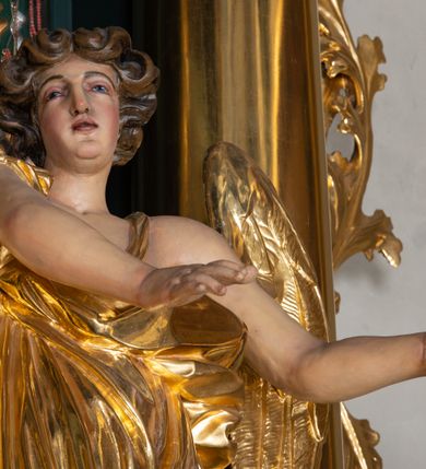 Zdjęcie nr 13: Nastawa architektoniczna, trójosiowa, dwukondygnacyjna, ustawiona na wysokim cokole z wyodrębnionymi prostopadłościanami. Ołtarz prostopadłościenny, z drewnianą mensą. Antepedium ujęte profilowaną ramą, w polu medalion z monogramem IHS w glorii. Na ołtarzu ustawione tabernakulum z tronem wystawienia. Tabernakulum w formie trójosiowej skrzynki, o wklęsło-wypukłym licu, artykułowanej kolumienkami o kręconych trzonach, podtrzymującymi belkowanie, wyłamane na ich osi, z gzymsem wyłamanym faliście na osi środkowej. Drzwiczki w formie stojącego prostokąta zamkniętego łukiem półkolistym nadwieszonym z uskokiem, ujętego ramą z płaskorzeźbionym przedstawieniem kielicha z hostią w glorii. Na osiach bocznych płaskorzeźbione przedstawienia winnego grona. Tron wystawienia w formie paludamentu, podwójnie podwieszonego po bokach, zwieńczonego koroną zamkniętą. 
Cokół dekorowany płycinami wypełnionymi suchym akantem. Pierwsza kondygnacja nastawy ujęta dwiema parami kolumn o kapitelach kompozytowych oraz stojącą między nimi parą pilastrów, w których trzonach znajdują się gabloty na wota. Przed pilastrami na cokołach ustawione dwie figury aniołów. Podpory dźwigają pełne belkowanie, przerwane w partii architrawu i fryzu nad polem środkowym, wyłamane na osi kolumn, na osi pilastrów belkowanie wyłamane pod kątem, w formie impostu z podwieszonymi szyszkami. Na belkowaniu, na obłokach dwie figurki adorujących puttów oraz dwa wazony na cokołach. W polu środkowym wnęka w formie stojącego prostokąta o wciętych górnych narożach, ujęta podwójną ramą, dekorowaną ornamentem roślinnym, z obrazem św. Józefa. Wnęka otoczona z trzech stron gablotami z wotami. Nad nią, w polu belkowania kartusz utworzony z suchego akantu z napisem w polu: „ŚW(IĘTY) JÓZEFIE / MÓDL SIĘ / ZA NAMI”. Druga kondygnacja o szerokości osi środkowej, ustawiona na cokole z wyodrębnionymi prostopadłościanami oraz gablotą z wotami, ujęta dwiema parami pilastrów i spływami wolutowymi oraz stojącą przed nimi parą kolumn, dźwigających zdwojone imposty oraz fragmenty przerwanego, półkolistego przyczółka z siedzącymi puttami. Spływy zdobione festonami utworzonymi z wstęgi oraz kwiatów. Całość zamknięta fragmentem falistego gzymsu oraz Okiem Opatrzności w glorii promienistej. W polu obraz Zaślubin Marii ze św. Józefem w formie stojącego prostokąta o ściętych narożach, ujęty ramą dekorowaną ornamentem roślinnym. Flankowany dwiema prostokątnymi płycinami wypełnionymi akantem. Obie kondygnacje ujęte uszami utworzonymi z suchego akantu. Struktura polichromowana w kolorze zielonym, kolumny, ornamentyka i profile złocone.




