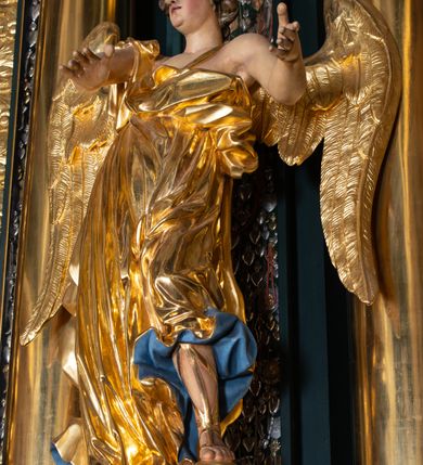 Zdjęcie nr 16: Nastawa architektoniczna, trójosiowa, dwukondygnacyjna, ustawiona na wysokim cokole z wyodrębnionymi prostopadłościanami. Ołtarz prostopadłościenny, z drewnianą mensą. Antepedium ujęte profilowaną ramą, w polu medalion z monogramem IHS w glorii. Na ołtarzu ustawione tabernakulum z tronem wystawienia. Tabernakulum w formie trójosiowej skrzynki, o wklęsło-wypukłym licu, artykułowanej kolumienkami o kręconych trzonach, podtrzymującymi belkowanie, wyłamane na ich osi, z gzymsem wyłamanym faliście na osi środkowej. Drzwiczki w formie stojącego prostokąta zamkniętego łukiem półkolistym nadwieszonym z uskokiem, ujętego ramą z płaskorzeźbionym przedstawieniem kielicha z hostią w glorii. Na osiach bocznych płaskorzeźbione przedstawienia winnego grona. Tron wystawienia w formie paludamentu, podwójnie podwieszonego po bokach, zwieńczonego koroną zamkniętą. 
Cokół dekorowany płycinami wypełnionymi suchym akantem. Pierwsza kondygnacja nastawy ujęta dwiema parami kolumn o kapitelach kompozytowych oraz stojącą między nimi parą pilastrów, w których trzonach znajdują się gabloty na wota. Przed pilastrami na cokołach ustawione dwie figury aniołów. Podpory dźwigają pełne belkowanie, przerwane w partii architrawu i fryzu nad polem środkowym, wyłamane na osi kolumn, na osi pilastrów belkowanie wyłamane pod kątem, w formie impostu z podwieszonymi szyszkami. Na belkowaniu, na obłokach dwie figurki adorujących puttów oraz dwa wazony na cokołach. W polu środkowym wnęka w formie stojącego prostokąta o wciętych górnych narożach, ujęta podwójną ramą, dekorowaną ornamentem roślinnym, z obrazem św. Józefa. Wnęka otoczona z trzech stron gablotami z wotami. Nad nią, w polu belkowania kartusz utworzony z suchego akantu z napisem w polu: „ŚW(IĘTY) JÓZEFIE / MÓDL SIĘ / ZA NAMI”. Druga kondygnacja o szerokości osi środkowej, ustawiona na cokole z wyodrębnionymi prostopadłościanami oraz gablotą z wotami, ujęta dwiema parami pilastrów i spływami wolutowymi oraz stojącą przed nimi parą kolumn, dźwigających zdwojone imposty oraz fragmenty przerwanego, półkolistego przyczółka z siedzącymi puttami. Spływy zdobione festonami utworzonymi z wstęgi oraz kwiatów. Całość zamknięta fragmentem falistego gzymsu oraz Okiem Opatrzności w glorii promienistej. W polu obraz Zaślubin Marii ze św. Józefem w formie stojącego prostokąta o ściętych narożach, ujęty ramą dekorowaną ornamentem roślinnym. Flankowany dwiema prostokątnymi płycinami wypełnionymi akantem. Obie kondygnacje ujęte uszami utworzonymi z suchego akantu. Struktura polichromowana w kolorze zielonym, kolumny, ornamentyka i profile złocone.




