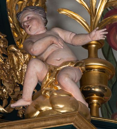 Zdjęcie nr 27: Nastawa architektoniczna, trójosiowa, dwukondygnacyjna, ustawiona na wysokim cokole z wyodrębnionymi prostopadłościanami. Ołtarz prostopadłościenny, z drewnianą mensą. Antepedium ujęte profilowaną ramą, w polu medalion z monogramem IHS w glorii. Na ołtarzu ustawione tabernakulum z tronem wystawienia. Tabernakulum w formie trójosiowej skrzynki, o wklęsło-wypukłym licu, artykułowanej kolumienkami o kręconych trzonach, podtrzymującymi belkowanie, wyłamane na ich osi, z gzymsem wyłamanym faliście na osi środkowej. Drzwiczki w formie stojącego prostokąta zamkniętego łukiem półkolistym nadwieszonym z uskokiem, ujętego ramą z płaskorzeźbionym przedstawieniem kielicha z hostią w glorii. Na osiach bocznych płaskorzeźbione przedstawienia winnego grona. Tron wystawienia w formie paludamentu, podwójnie podwieszonego po bokach, zwieńczonego koroną zamkniętą. 
Cokół dekorowany płycinami wypełnionymi suchym akantem. Pierwsza kondygnacja nastawy ujęta dwiema parami kolumn o kapitelach kompozytowych oraz stojącą między nimi parą pilastrów, w których trzonach znajdują się gabloty na wota. Przed pilastrami na cokołach ustawione dwie figury aniołów. Podpory dźwigają pełne belkowanie, przerwane w partii architrawu i fryzu nad polem środkowym, wyłamane na osi kolumn, na osi pilastrów belkowanie wyłamane pod kątem, w formie impostu z podwieszonymi szyszkami. Na belkowaniu, na obłokach dwie figurki adorujących puttów oraz dwa wazony na cokołach. W polu środkowym wnęka w formie stojącego prostokąta o wciętych górnych narożach, ujęta podwójną ramą, dekorowaną ornamentem roślinnym, z obrazem św. Józefa. Wnęka otoczona z trzech stron gablotami z wotami. Nad nią, w polu belkowania kartusz utworzony z suchego akantu z napisem w polu: „ŚW(IĘTY) JÓZEFIE / MÓDL SIĘ / ZA NAMI”. Druga kondygnacja o szerokości osi środkowej, ustawiona na cokole z wyodrębnionymi prostopadłościanami oraz gablotą z wotami, ujęta dwiema parami pilastrów i spływami wolutowymi oraz stojącą przed nimi parą kolumn, dźwigających zdwojone imposty oraz fragmenty przerwanego, półkolistego przyczółka z siedzącymi puttami. Spływy zdobione festonami utworzonymi z wstęgi oraz kwiatów. Całość zamknięta fragmentem falistego gzymsu oraz Okiem Opatrzności w glorii promienistej. W polu obraz Zaślubin Marii ze św. Józefem w formie stojącego prostokąta o ściętych narożach, ujęty ramą dekorowaną ornamentem roślinnym. Flankowany dwiema prostokątnymi płycinami wypełnionymi akantem. Obie kondygnacje ujęte uszami utworzonymi z suchego akantu. Struktura polichromowana w kolorze zielonym, kolumny, ornamentyka i profile złocone.




