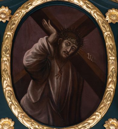 Zdjęcie nr 5: Nastawa architektoniczna, jednoosiowa, jednokondygnacyjna ze zwieńczeniem, ustawiona na dwustrefowym cokole z wyodrębnionymi dwoma prostopadłościanami. Ołtarz prostopadłościenny, z drewnianą mensą. Antepedium ujęte profilowaną, złoconą ramą, na tle fioletowego pola mandorla z chrystogramem Chi Rho oraz literami alfa i omega, w glorii promienistej. Cokół w górnej strefie dekorowany płycinami wypełnionymi akantem. Nastawa flankowana parą kolumn o kapitelach kompozytowych, dźwigających pełne belkowanie, wyłamane pod kątem na ich osi, z siedzącymi na nim puttami, o fryzie dekorowanym rozetami. Pole centralne niemal w całości wypełnione wnęką ujętą profilowaną ramą zdobioną miejscami ornamentem roślinnym, w formie stojącego prostokąta o wklęsłych górnych narożach. We wnęce obraz z przedstawieniem św. Antoniego Padewskiego, na zasuwie św. Elżbiety Węgierskiej. Nad obrazem, w polu belkowania kartusz utworzony z akantu, kampanuli i liści z napisem „S(ANC)T(E) ANTONI / ORA PRO NOBIS”. Kondygnacja ujęta uszami utworzonymi z akantu i kampanuli. Zwieńczenie w formie stojącego prostokąta o lekko wklęsłych bokach, zamknięte fragmentem falistego gzymsu, na którym siedzi putto i uskrzydlona główka anielska. W polu obraz Chrystusa dźwigającego krzyż w formie stojącego owalu, ujęty ramą zdobioną wieńcem laurowym. Zwieńczenie dekorowane w polu czterema rozetami, flankowane uszami z akantu. Struktura polichromowana w kolorze zielonym, ze złoconymi kolumnami, profilami i ornamentyką. 