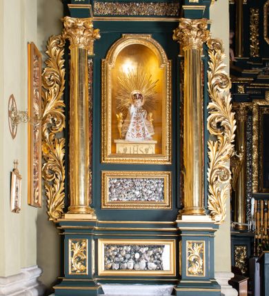 Zdjęcie nr 1: Nastawa architektoniczne, jednoosiowa, dwukondygnacyjna, ustawiona na cokole z wyodrębnionymi dwoma prostopadłościanami. Ołtarz prostopadłościenny, z drewnianą mensą. Antepedium ujęte profilowaną ramą, w polu medalion z monogramem IHS w glorii. Cokół dekorowany płycinami w partii wyodrębnionych prostopadłościanów wypełnionymi akantem, w partii środkowej gablotą na wota. Pierwsza kondygnacja flankowana parą pilastrów o trzonach w formie gablot z wotami i stojących przed nimi kolumnami o kapitelach kompozytowych, dźwigających pełne belkowanie, wyłamane na ich osi, o fryzie dekorowanym rozetami, z gablotą z wotami pośrodku. W polu centralnym nisza w formie stojącego prostokąta, zamkniętego łukiem półkolistym nadwieszonym, ujęta podwójną ramą zdobioną ornamentem roślinnym, z figurką Dzieciątka Koletańskiego. Pod nią gablota na wota w formie leżącego prostokąta w ramie dekorowanej ornamentem roślinnym. Druga kondygnacja ustawiona na cokole z wyodrębnionymi prostopadłościanami, flankowana parą pilastrów i stojących przed nimi kolumn o kapitelach kompozytowych, dźwigających imposty i fragmenty przerwanego, półkolistego przyczółka. Całość zamknięta fragmentem falistego gzymsu. W polu obraz bł. Władysława z Gielniowa w formie stojącego prostokąta o ściętych narożach, ujętego ramą zdobioną ornamentem roślinnym. Obie kondygnacje z uszami utworzonymi ze stylizowanego akantu. Struktura polichromowana w kolorze zielonym, ze złoconymi kolumnami, profilami i ornamentyką. 