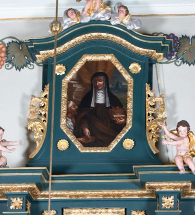 Zdjęcie nr 3: Nastawa architektoniczna, jednoosiowa, jednokondygnacyjna ze zwieńczeniem, ustawiona na dwustrefowym cokole z wyodrębnionymi dwoma prostopadłościanami. Ołtarz prostopadłościenny, z drewnianą mensą. Antepedium ujęte profilowaną, złoconą ramą, na tle fioletowego pola mandorla z chrystogramem Chi Rho oraz literami alfa i omega, w glorii promienistej. Cokół w górnej strefie dekorowany płycinami wypełnionymi akantem. Nastawa flankowana parą kolumn o kapitelach kompozytowych, dźwigających pełne belkowanie, wyłamane na ich osi, częściowo przerwane pośrodku, z siedzącymi na nim puttami, o fryzie dekorowanym rozetami. Pole centralne niemal w całości wypełnione wnęką ujętą ramą zdobioną ornamentem roślinnym, w formie stojącego prostokąta z wyłamanym schodkowo fragmentem w górnym boku, wypełnionym akantem. We wnęce obraz „Stygmatyzacja św. Franciszka”, na zasuwie przedstawienie św. Klary. Kondygnacja ujęta uszami utworzonymi z akantu i kampanuli. Zwieńczenie w formie stojącego prostokąta o lekko wklęsłych bokach, zamknięte fragmentem falistego gzymsu z obłokami, puttem i dwoma uskrzydlonymi główkami anielskimi. W polu obraz św. Elżbiety Węgierskiej w formie stojącego prostokąta o ściętych narożach, ujęty ramą zdobioną ornamentem roślinnym. W miejscu naroży cztery rozety. Zwieńczenie flankowane uszami z akantu i kampanuli. Struktura polichromowana w kolorze zielonym, ze złoconymi kolumnami, profilami i ornamentyką. 