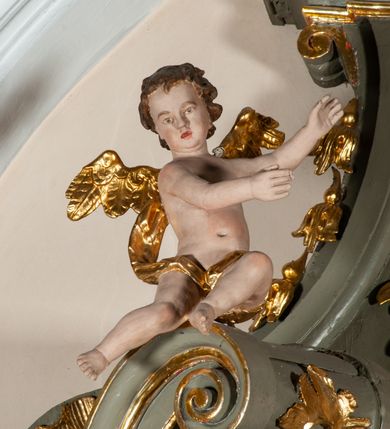 Zdjęcie nr 16: Ołtarz jednoosiowy, jednokondygnacyjny ze zwieńczeniem. Podwójny cokół z wąską, drewnianą mensą ołtarzową, tabernakulum ze spływami wolutowymi. Retabulum flankowane dwiema ćwierć kolumnami skierowanymi po ukosie na zewnątrz, z których każda ujęta parą korynckich, kanelowanych pilastrów dźwigających przełamujące się nad nimi belkowanie i dwa faliste naczółki. Na tle pilastrów, na konsolach stoją dwa uskrzydlone anioły. Zwieńczenie ujęte spływami wolutowymi, zakończone dwiema profilowanym, lekko falistym gzymsem z dwiema stykającymi się wolutami. W polu głównym szeroka, złocona, prostokątna rama z obrazami „Św. Mikołaj” i "Wizja św. Franciszka" na zasuwie, w zwieńczeniu owalny obraz w złoconej ramie z przedstawieniem św. Antoniego. Figury aniołów wydrążone, ukazane w kontrapoście, z dłońmi wysuniętymi do przodu; anioł po lewej trzyma chustę. Ich twarze są owalne o regularnych rysach, z brązowymi puklowanymi włosami sięgającymi ramion. Z tyłu przymocowane duże, złote skrzydła. Ubrane są w długie, złote szaty o ostrym zarysie, odsłaniające klatkę piersiową i jedną z nóg. W partii belkowania para nagich puttów ze złoconymi opaskami na biodrach ujmujących kartusz w rokokowym obramieniu z chrystogramem. Na naczółkach z kolei siedzą nagie putta z przepaskami na biodrach i złotymi skrzydełkami. Na dekorację ornamentalną składają się drobne motywy roślinne, kampanule na ćwierćkolumnach, zwisy róż i gałązek wokół obrazu w zwieńczeniu i efektowna podwójna muszla palmetowa w zwieńczeniu. 
