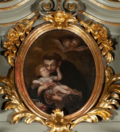 Zdjęcie nr 21: Ołtarz jednoosiowy, jednokondygnacyjny ze zwieńczeniem. Podwójny cokół z wąską, drewnianą mensą ołtarzową, tabernakulum ze spływami wolutowymi. Retabulum flankowane dwiema ćwierć kolumnami skierowanymi po ukosie na zewnątrz, z których każda ujęta parą korynckich, kanelowanych pilastrów dźwigających przełamujące się nad nimi belkowanie i dwa faliste naczółki. Na tle pilastrów, na konsolach stoją dwa uskrzydlone anioły. Zwieńczenie ujęte spływami wolutowymi, zakończone dwiema profilowanym, lekko falistym gzymsem z dwiema stykającymi się wolutami. W polu głównym szeroka, złocona, prostokątna rama z obrazami „Św. Mikołaj” i &quot;Wizja św. Franciszka&quot; na zasuwie, w zwieńczeniu owalny obraz w złoconej ramie z przedstawieniem św. Antoniego. Figury aniołów wydrążone, ukazane w kontrapoście, z dłońmi wysuniętymi do przodu; anioł po lewej trzyma chustę. Ich twarze są owalne o regularnych rysach, z brązowymi puklowanymi włosami sięgającymi ramion. Z tyłu przymocowane duże, złote skrzydła. Ubrane są w długie, złote szaty o ostrym zarysie, odsłaniające klatkę piersiową i jedną z nóg. W partii belkowania para nagich puttów ze złoconymi opaskami na biodrach ujmujących kartusz w rokokowym obramieniu z chrystogramem. Na naczółkach z kolei siedzą nagie putta z przepaskami na biodrach i złotymi skrzydełkami. Na dekorację ornamentalną składają się drobne motywy roślinne, kampanule na ćwierćkolumnach, zwisy róż i gałązek wokół obrazu w zwieńczeniu i efektowna podwójna muszla palmetowa w zwieńczeniu. 
