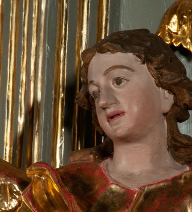 Zdjęcie nr 6: Ołtarz jednoosiowy, jednokondygnacyjny ze zwieńczeniem. Podwójny cokół z wąską, drewnianą mensą ołtarzową, tabernakulum ze spływami wolutowymi. Retabulum flankowane dwiema ćwierć kolumnami skierowanymi po ukosie na zewnątrz, z których każda ujęta parą korynckich, kanelowanych pilastrów dźwigających przełamujące się nad nimi belkowanie i dwa faliste naczółki. Na tle pilastrów, na konsolach stoją dwa uskrzydlone anioły. Zwieńczenie ujęte spływami wolutowymi, zakończone dwiema profilowanym, lekko falistym gzymsem z dwiema stykającymi się wolutami. W polu głównym szeroka, złocona, prostokątna rama z obrazami „Św. Mikołaj” i "Wizja św. Franciszka" na zasuwie, w zwieńczeniu owalny obraz w złoconej ramie z przedstawieniem św. Antoniego. Figury aniołów wydrążone, ukazane w kontrapoście, z dłońmi wysuniętymi do przodu; anioł po lewej trzyma chustę. Ich twarze są owalne o regularnych rysach, z brązowymi puklowanymi włosami sięgającymi ramion. Z tyłu przymocowane duże, złote skrzydła. Ubrane są w długie, złote szaty o ostrym zarysie, odsłaniające klatkę piersiową i jedną z nóg. W partii belkowania para nagich puttów ze złoconymi opaskami na biodrach ujmujących kartusz w rokokowym obramieniu z chrystogramem. Na naczółkach z kolei siedzą nagie putta z przepaskami na biodrach i złotymi skrzydełkami. Na dekorację ornamentalną składają się drobne motywy roślinne, kampanule na ćwierćkolumnach, zwisy róż i gałązek wokół obrazu w zwieńczeniu i efektowna podwójna muszla palmetowa w zwieńczeniu. 
