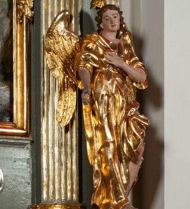 Zdjęcie nr 8: Ołtarz jednoosiowy, jednokondygnacyjny ze zwieńczeniem. Podwójny cokół z wąską, drewnianą mensą ołtarzową, tabernakulum ze spływami wolutowymi. Retabulum flankowane dwiema ćwierć kolumnami skierowanymi po ukosie na zewnątrz, z których każda ujęta parą korynckich, kanelowanych pilastrów dźwigających przełamujące się nad nimi belkowanie i dwa faliste naczółki. Na tle pilastrów, na konsolach stoją dwa uskrzydlone anioły. Zwieńczenie ujęte spływami wolutowymi, zakończone dwiema profilowanym, lekko falistym gzymsem z dwiema stykającymi się wolutami. W polu głównym szeroka, złocona, prostokątna rama z obrazami „Św. Mikołaj” i "Wizja św. Franciszka" na zasuwie, w zwieńczeniu owalny obraz w złoconej ramie z przedstawieniem św. Antoniego. Figury aniołów wydrążone, ukazane w kontrapoście, z dłońmi wysuniętymi do przodu; anioł po lewej trzyma chustę. Ich twarze są owalne o regularnych rysach, z brązowymi puklowanymi włosami sięgającymi ramion. Z tyłu przymocowane duże, złote skrzydła. Ubrane są w długie, złote szaty o ostrym zarysie, odsłaniające klatkę piersiową i jedną z nóg. W partii belkowania para nagich puttów ze złoconymi opaskami na biodrach ujmujących kartusz w rokokowym obramieniu z chrystogramem. Na naczółkach z kolei siedzą nagie putta z przepaskami na biodrach i złotymi skrzydełkami. Na dekorację ornamentalną składają się drobne motywy roślinne, kampanule na ćwierćkolumnach, zwisy róż i gałązek wokół obrazu w zwieńczeniu i efektowna podwójna muszla palmetowa w zwieńczeniu. 
