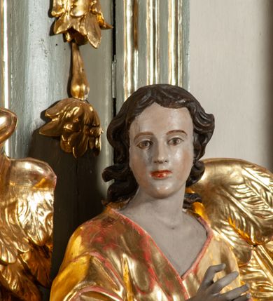 Zdjęcie nr 29: Ołtarz  jednoosiowy, jednokondygnacyjny ze zwieńczeniem. Podwójny cokół z wąską, drewnianą mensą ołtarzową, tabernakulum ze spływami wolutowymi. Retabulum flankowane dwiema ćwierć kolumnami skierowanymi po ukosie na zewnątrz, z których każda ujęta parą korynckich, kanelowanych pilastrów dźwigających przełamujące się nad nimi belkowanie i dwa faliste naczółki. Na tle pilastrów, na konsolach stoją dwa uskrzydlone anioły. Zwieńczenie ujęte spływami wolutowymi, zakończone profilowanym, lekko falistym gzymsem z dwiema stykającymi się wolutami. W polu głównym szeroka, złocona, prostokątna rama z obrazem "Św. Szymon Oracz", w zwieńczeniu owalny obraz w złoconej ramie z przedstawieniem św. Michała Archanioła. Figury aniołów wydrążone, ukazane w kontrapoście, o prawidłowych proporcjach ciała, w lekkim przechyleniu na bok, z dłońmi ułożonymi do gry na instrumencie szarpanym. Ich twarze są owalne o regularnych rysach, z brązowymi puklowanymi włosami sięgającymi ramion. Z tyłu przymocowane duże, złote skrzydła. Ubrani są w długie, złote szaty o ostrym zarysie. W partii belkowania para nagich puttów ze złoconymi opaskami na biodrach ujmują kartusz w rokokowym obramieniu. Na naczółkach z kolei siedzą nagie putta z przepaskami na biodrach i złotymi skrzydełkami. Na dekorację ornamentalną składają się drobne motywy roślinne, kampanule na ćwierćkolumnach, zwisy róż i gałązek wokół obrazu w zwieńczeniu i efektowna podwójna muszla palmetowa w zwieńczeniu. 



