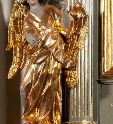 Zdjęcie nr 3: Ołtarz  jednoosiowy, jednokondygnacyjny ze zwieńczeniem. Podwójny cokół z wąską, drewnianą mensą ołtarzową, tabernakulum ze spływami wolutowymi. Retabulum flankowane dwiema ćwierć kolumnami skierowanymi po ukosie na zewnątrz, z których każda ujęta parą korynckich, kanelowanych pilastrów dźwigających przełamujące się nad nimi belkowanie i dwa faliste naczółki. Na tle pilastrów, na konsolach stoją dwa uskrzydlone anioły. Zwieńczenie ujęte spływami wolutowymi, zakończone profilowanym, lekko falistym gzymsem z dwiema stykającymi się wolutami. W polu głównym szeroka, złocona, prostokątna rama z obrazem "Św. Szymon Oracz", w zwieńczeniu owalny obraz w złoconej ramie z przedstawieniem św. Michała Archanioła. Figury aniołów wydrążone, ukazane w kontrapoście, o prawidłowych proporcjach ciała, w lekkim przechyleniu na bok, z dłońmi ułożonymi do gry na instrumencie szarpanym. Ich twarze są owalne o regularnych rysach, z brązowymi puklowanymi włosami sięgającymi ramion. Z tyłu przymocowane duże, złote skrzydła. Ubrani są w długie, złote szaty o ostrym zarysie. W partii belkowania para nagich puttów ze złoconymi opaskami na biodrach ujmują kartusz w rokokowym obramieniu. Na naczółkach z kolei siedzą nagie putta z przepaskami na biodrach i złotymi skrzydełkami. Na dekorację ornamentalną składają się drobne motywy roślinne, kampanule na ćwierćkolumnach, zwisy róż i gałązek wokół obrazu w zwieńczeniu i efektowna podwójna muszla palmetowa w zwieńczeniu. 



