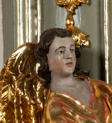 Zdjęcie nr 7: Ołtarz  jednoosiowy, jednokondygnacyjny ze zwieńczeniem. Podwójny cokół z wąską, drewnianą mensą ołtarzową, tabernakulum ze spływami wolutowymi. Retabulum flankowane dwiema ćwierć kolumnami skierowanymi po ukosie na zewnątrz, z których każda ujęta parą korynckich, kanelowanych pilastrów dźwigających przełamujące się nad nimi belkowanie i dwa faliste naczółki. Na tle pilastrów, na konsolach stoją dwa uskrzydlone anioły. Zwieńczenie ujęte spływami wolutowymi, zakończone profilowanym, lekko falistym gzymsem z dwiema stykającymi się wolutami. W polu głównym szeroka, złocona, prostokątna rama z obrazem "Św. Szymon Oracz", w zwieńczeniu owalny obraz w złoconej ramie z przedstawieniem św. Michała Archanioła. Figury aniołów wydrążone, ukazane w kontrapoście, o prawidłowych proporcjach ciała, w lekkim przechyleniu na bok, z dłońmi ułożonymi do gry na instrumencie szarpanym. Ich twarze są owalne o regularnych rysach, z brązowymi puklowanymi włosami sięgającymi ramion. Z tyłu przymocowane duże, złote skrzydła. Ubrani są w długie, złote szaty o ostrym zarysie. W partii belkowania para nagich puttów ze złoconymi opaskami na biodrach ujmują kartusz w rokokowym obramieniu. Na naczółkach z kolei siedzą nagie putta z przepaskami na biodrach i złotymi skrzydełkami. Na dekorację ornamentalną składają się drobne motywy roślinne, kampanule na ćwierćkolumnach, zwisy róż i gałązek wokół obrazu w zwieńczeniu i efektowna podwójna muszla palmetowa w zwieńczeniu. 



