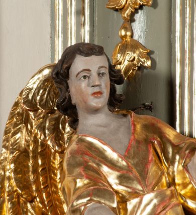 Zdjęcie nr 8: Ołtarz  jednoosiowy, jednokondygnacyjny ze zwieńczeniem. Podwójny cokół z wąską, drewnianą mensą ołtarzową, tabernakulum ze spływami wolutowymi. Retabulum flankowane dwiema ćwierć kolumnami skierowanymi po ukosie na zewnątrz, z których każda ujęta parą korynckich, kanelowanych pilastrów dźwigających przełamujące się nad nimi belkowanie i dwa faliste naczółki. Na tle pilastrów, na konsolach stoją dwa uskrzydlone anioły. Zwieńczenie ujęte spływami wolutowymi, zakończone profilowanym, lekko falistym gzymsem z dwiema stykającymi się wolutami. W polu głównym szeroka, złocona, prostokątna rama z obrazem "Św. Szymon Oracz", w zwieńczeniu owalny obraz w złoconej ramie z przedstawieniem św. Michała Archanioła. Figury aniołów wydrążone, ukazane w kontrapoście, o prawidłowych proporcjach ciała, w lekkim przechyleniu na bok, z dłońmi ułożonymi do gry na instrumencie szarpanym. Ich twarze są owalne o regularnych rysach, z brązowymi puklowanymi włosami sięgającymi ramion. Z tyłu przymocowane duże, złote skrzydła. Ubrani są w długie, złote szaty o ostrym zarysie. W partii belkowania para nagich puttów ze złoconymi opaskami na biodrach ujmują kartusz w rokokowym obramieniu. Na naczółkach z kolei siedzą nagie putta z przepaskami na biodrach i złotymi skrzydełkami. Na dekorację ornamentalną składają się drobne motywy roślinne, kampanule na ćwierćkolumnach, zwisy róż i gałązek wokół obrazu w zwieńczeniu i efektowna podwójna muszla palmetowa w zwieńczeniu. 



