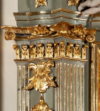 Zdjęcie nr 10: Ołtarz  jednoosiowy, jednokondygnacyjny ze zwieńczeniem. Podwójny cokół z wąską, drewnianą mensą ołtarzową, tabernakulum ze spływami wolutowymi. Retabulum flankowane dwiema ćwierć kolumnami skierowanymi po ukosie na zewnątrz, z których każda ujęta parą korynckich, kanelowanych pilastrów dźwigających przełamujące się nad nimi belkowanie i dwa faliste naczółki. Na tle pilastrów, na konsolach stoją dwa uskrzydlone anioły. Zwieńczenie ujęte spływami wolutowymi, zakończone profilowanym, lekko falistym gzymsem z dwiema stykającymi się wolutami. W polu głównym szeroka, złocona, prostokątna rama z obrazem "Św. Szymon Oracz", w zwieńczeniu owalny obraz w złoconej ramie z przedstawieniem św. Michała Archanioła. Figury aniołów wydrążone, ukazane w kontrapoście, o prawidłowych proporcjach ciała, w lekkim przechyleniu na bok, z dłońmi ułożonymi do gry na instrumencie szarpanym. Ich twarze są owalne o regularnych rysach, z brązowymi puklowanymi włosami sięgającymi ramion. Z tyłu przymocowane duże, złote skrzydła. Ubrani są w długie, złote szaty o ostrym zarysie. W partii belkowania para nagich puttów ze złoconymi opaskami na biodrach ujmują kartusz w rokokowym obramieniu. Na naczółkach z kolei siedzą nagie putta z przepaskami na biodrach i złotymi skrzydełkami. Na dekorację ornamentalną składają się drobne motywy roślinne, kampanule na ćwierćkolumnach, zwisy róż i gałązek wokół obrazu w zwieńczeniu i efektowna podwójna muszla palmetowa w zwieńczeniu. 



