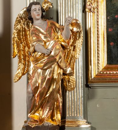 Zdjęcie nr 5: Ołtarz  jednoosiowy, jednokondygnacyjny ze zwieńczeniem. Podwójny cokół z wąską, drewnianą mensą ołtarzową, tabernakulum ze spływami wolutowymi. Retabulum flankowane dwiema ćwierć kolumnami skierowanymi po ukosie na zewnątrz, z których każda ujęta parą korynckich, kanelowanych pilastrów dźwigających przełamujące się nad nimi belkowanie i dwa faliste naczółki. Na tle pilastrów, na konsolach stoją dwa uskrzydlone anioły. Zwieńczenie ujęte spływami wolutowymi, zakończone profilowanym, lekko falistym gzymsem z dwiema stykającymi się wolutami. W polu głównym szeroka, złocona, prostokątna rama z obrazem "Św. Szymon Oracz", w zwieńczeniu owalny obraz w złoconej ramie z przedstawieniem św. Michała Archanioła. Figury aniołów wydrążone, ukazane w kontrapoście, o prawidłowych proporcjach ciała, w lekkim przechyleniu na bok, z dłońmi ułożonymi do gry na instrumencie szarpanym. Ich twarze są owalne o regularnych rysach, z brązowymi puklowanymi włosami sięgającymi ramion. Z tyłu przymocowane duże, złote skrzydła. Ubrani są w długie, złote szaty o ostrym zarysie. W partii belkowania para nagich puttów ze złoconymi opaskami na biodrach ujmują kartusz w rokokowym obramieniu. Na naczółkach z kolei siedzą nagie putta z przepaskami na biodrach i złotymi skrzydełkami. Na dekorację ornamentalną składają się drobne motywy roślinne, kampanule na ćwierćkolumnach, zwisy róż i gałązek wokół obrazu w zwieńczeniu i efektowna podwójna muszla palmetowa w zwieńczeniu. 



