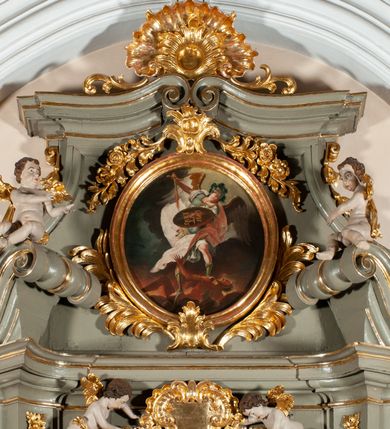 Zdjęcie nr 18: Ołtarz  jednoosiowy, jednokondygnacyjny ze zwieńczeniem. Podwójny cokół z wąską, drewnianą mensą ołtarzową, tabernakulum ze spływami wolutowymi. Retabulum flankowane dwiema ćwierć kolumnami skierowanymi po ukosie na zewnątrz, z których każda ujęta parą korynckich, kanelowanych pilastrów dźwigających przełamujące się nad nimi belkowanie i dwa faliste naczółki. Na tle pilastrów, na konsolach stoją dwa uskrzydlone anioły. Zwieńczenie ujęte spływami wolutowymi, zakończone profilowanym, lekko falistym gzymsem z dwiema stykającymi się wolutami. W polu głównym szeroka, złocona, prostokątna rama z obrazem "Św. Szymon Oracz", w zwieńczeniu owalny obraz w złoconej ramie z przedstawieniem św. Michała Archanioła. Figury aniołów wydrążone, ukazane w kontrapoście, o prawidłowych proporcjach ciała, w lekkim przechyleniu na bok, z dłońmi ułożonymi do gry na instrumencie szarpanym. Ich twarze są owalne o regularnych rysach, z brązowymi puklowanymi włosami sięgającymi ramion. Z tyłu przymocowane duże, złote skrzydła. Ubrani są w długie, złote szaty o ostrym zarysie. W partii belkowania para nagich puttów ze złoconymi opaskami na biodrach ujmują kartusz w rokokowym obramieniu. Na naczółkach z kolei siedzą nagie putta z przepaskami na biodrach i złotymi skrzydełkami. Na dekorację ornamentalną składają się drobne motywy roślinne, kampanule na ćwierćkolumnach, zwisy róż i gałązek wokół obrazu w zwieńczeniu i efektowna podwójna muszla palmetowa w zwieńczeniu. 



