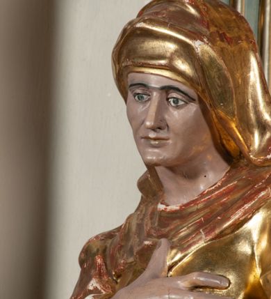 Zdjęcie nr 10: Ołtarz jednoosiowy, jednokondygnacyjny ze zwieńczeniem. Podwójny cokół z wąską, drewnianą mensą ołtarzową, wybrzuszoną. Na niej stoi tabernakulum ujęte narożnie ustawionymi spływami wolutowymi, zwieńczone spłaszczoną kopułką ze spływami wolutowymi. Retabulum flankowane dwiema ćwierć kolumnami skierowanymi po ukosie na zewnątrz, z których każda ujęta parą korynckich, kanelowanych pilastrów dźwigających przełamujące się nad nimi belkowanie i dwa faliste naczółki. Na tle pilastrów, na konsolach stoją figury św. Anny i św. Joachima oraz unoszą się na chmurach flankujące obraz uskrzydlone anioły. Zwieńczenie ujęte spływami wolutowymi, zakończone profilowanym, lekko falistym gzymsem z dwiema stykającymi się wolutami. N naczółkach dwa uskrzydlone, przepasane opaską na biodrach aniołki. W polu głównym szeroka, złocona, prostokątna rama z obrazem Matki Boskiej z Dzieciątkiem i koroną w partii belkowania, a w zwieńczeniu owalny obraz w złoconej ramie z przedstawieniem św. Józefa z Dzieciątkiem. Figury św. Anny i św. Joachima ukazane w lekkim kontrapoście, w długich, obficie fałdowanych szatach. Anna trzyma prawą rękę na piersi, w lewej przytrzymuje połę płaszcza, natomiast Joachim ręce składa w geście modlitwy. Anioły klęczą na chmurach, usytuowanych na różnych poziomach, ubrane są w miękko, ale drobno fałdowane szaty, odsłaniające ich ramiona i górną część klatki piersiowej i wskazujący na obraz. Na dekorację ornamentalną składają się drobne motywy roślinne, kampanule na ćwierćkolumnach, zwisy róż i gałązek palm wokół obrazu w zwieńczeniu i efektowna podwójna muszla palmetowa w zwieńczeniu. 