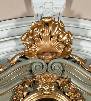 Zdjęcie nr 21: Ołtarz jednoosiowy, jednokondygnacyjny ze zwieńczeniem. Podwójny cokół z wąską, drewnianą mensą ołtarzową, wybrzuszoną. Na niej stoi tabernakulum ujęte narożnie ustawionymi spływami wolutowymi, zwieńczone spłaszczoną kopułką ze spływami wolutowymi. Retabulum flankowane dwiema ćwierć kolumnami skierowanymi po ukosie na zewnątrz, z których każda ujęta parą korynckich, kanelowanych pilastrów dźwigających przełamujące się nad nimi belkowanie i dwa faliste naczółki. Na tle pilastrów, na konsolach stoją figury św. Anny i św. Joachima oraz unoszą się na chmurach flankujące obraz uskrzydlone anioły. Zwieńczenie ujęte spływami wolutowymi, zakończone profilowanym, lekko falistym gzymsem z dwiema stykającymi się wolutami. N naczółkach dwa uskrzydlone, przepasane opaską na biodrach aniołki. W polu głównym szeroka, złocona, prostokątna rama z obrazem Matki Boskiej z Dzieciątkiem i koroną w partii belkowania, a w zwieńczeniu owalny obraz w złoconej ramie z przedstawieniem św. Józefa z Dzieciątkiem. Figury św. Anny i św. Joachima ukazane w lekkim kontrapoście, w długich, obficie fałdowanych szatach. Anna trzyma prawą rękę na piersi, w lewej przytrzymuje połę płaszcza, natomiast Joachim ręce składa w geście modlitwy. Anioły klęczą na chmurach, usytuowanych na różnych poziomach, ubrane są w miękko, ale drobno fałdowane szaty, odsłaniające ich ramiona i górną część klatki piersiowej i wskazujący na obraz. Na dekorację ornamentalną składają się drobne motywy roślinne, kampanule na ćwierćkolumnach, zwisy róż i gałązek palm wokół obrazu w zwieńczeniu i efektowna podwójna muszla palmetowa w zwieńczeniu. 