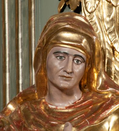 Zdjęcie nr 8: Ołtarz jednoosiowy, jednokondygnacyjny ze zwieńczeniem. Podwójny cokół z wąską, drewnianą mensą ołtarzową, wybrzuszoną. Na niej stoi tabernakulum ujęte narożnie ustawionymi spływami wolutowymi, zwieńczone spłaszczoną kopułką ze spływami wolutowymi. Retabulum flankowane dwiema ćwierć kolumnami skierowanymi po ukosie na zewnątrz, z których każda ujęta parą korynckich, kanelowanych pilastrów dźwigających przełamujące się nad nimi belkowanie i dwa faliste naczółki. Na tle pilastrów, na konsolach stoją figury św. Anny i św. Joachima oraz unoszą się na chmurach flankujące obraz uskrzydlone anioły. Zwieńczenie ujęte spływami wolutowymi, zakończone profilowanym, lekko falistym gzymsem z dwiema stykającymi się wolutami. N naczółkach dwa uskrzydlone, przepasane opaską na biodrach aniołki. W polu głównym szeroka, złocona, prostokątna rama z obrazem Matki Boskiej z Dzieciątkiem i koroną w partii belkowania, a w zwieńczeniu owalny obraz w złoconej ramie z przedstawieniem św. Józefa z Dzieciątkiem. Figury św. Anny i św. Joachima ukazane w lekkim kontrapoście, w długich, obficie fałdowanych szatach. Anna trzyma prawą rękę na piersi, w lewej przytrzymuje połę płaszcza, natomiast Joachim ręce składa w geście modlitwy. Anioły klęczą na chmurach, usytuowanych na różnych poziomach, ubrane są w miękko, ale drobno fałdowane szaty, odsłaniające ich ramiona i górną część klatki piersiowej i wskazujący na obraz. Na dekorację ornamentalną składają się drobne motywy roślinne, kampanule na ćwierćkolumnach, zwisy róż i gałązek palm wokół obrazu w zwieńczeniu i efektowna podwójna muszla palmetowa w zwieńczeniu. 