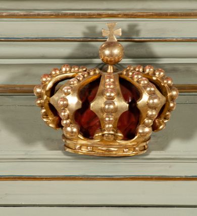 Zdjęcie nr 22: Ołtarz jednoosiowy, jednokondygnacyjny ze zwieńczeniem. Podwójny cokół z wąską, drewnianą mensą ołtarzową, wybrzuszoną. Na niej stoi tabernakulum ujęte narożnie ustawionymi spływami wolutowymi, zwieńczone spłaszczoną kopułką ze spływami wolutowymi. Retabulum flankowane dwiema ćwierć kolumnami skierowanymi po ukosie na zewnątrz, z których każda ujęta parą korynckich, kanelowanych pilastrów dźwigających przełamujące się nad nimi belkowanie i dwa faliste naczółki. Na tle pilastrów, na konsolach stoją figury św. Anny i św. Joachima oraz unoszą się na chmurach flankujące obraz uskrzydlone anioły. Zwieńczenie ujęte spływami wolutowymi, zakończone profilowanym, lekko falistym gzymsem z dwiema stykającymi się wolutami. N naczółkach dwa uskrzydlone, przepasane opaską na biodrach aniołki. W polu głównym szeroka, złocona, prostokątna rama z obrazem Matki Boskiej z Dzieciątkiem i koroną w partii belkowania, a w zwieńczeniu owalny obraz w złoconej ramie z przedstawieniem św. Józefa z Dzieciątkiem. Figury św. Anny i św. Joachima ukazane w lekkim kontrapoście, w długich, obficie fałdowanych szatach. Anna trzyma prawą rękę na piersi, w lewej przytrzymuje połę płaszcza, natomiast Joachim ręce składa w geście modlitwy. Anioły klęczą na chmurach, usytuowanych na różnych poziomach, ubrane są w miękko, ale drobno fałdowane szaty, odsłaniające ich ramiona i górną część klatki piersiowej i wskazujący na obraz. Na dekorację ornamentalną składają się drobne motywy roślinne, kampanule na ćwierćkolumnach, zwisy róż i gałązek palm wokół obrazu w zwieńczeniu i efektowna podwójna muszla palmetowa w zwieńczeniu. 