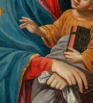 Zdjęcie nr 3: Obraz w kształcie stojącego prostokąta ukazuje na ciemnym, brązowym, jednolitym tle Matkę Boską z Dzieciątkiem na rękach. Maria ukazana jest do kolan, frontalnie, ze skrzyżowanymi rękoma, z których prawa z wyprostowanymi dwoma palcami, a lewa zaciśnięta z chustką. Jej twarz modelowana jest miękko, nos smukły, usta czerwone, uśmiechnięte, oczy otwarte, spoglądające na wprost. Ubrana jest w czerwoną suknię i niebieski płaszcz z różowym podbiciem, zarzucony na głowę. Jezus jest ukazany w trzech czwartych, zwrócony w prawo. Twarz ma pulchną, oczy szeroko otwarte, nos krótki, usta pełne, zaczerwienione, włosy jasne, kręcone, krótkie. Jest ubrany w brązową sukienkę i białą pieluchę wokół bioder i nóg. Prawą rękę unosi w kierunku gwiazdy na lewym ramieniu Marii, a w prawej trzyma księgę, na okładce której widnieją litery IHS w glorii promienistej. Wokół głowy Marii i Jezusa rozświetlone nimby. 
