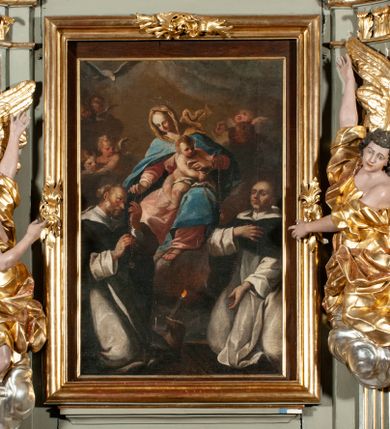 Zdjęcie nr 1: Obraz w kształcie stojącego prostokąta ukazuje siedzącą na chmurach Matkę Boską z Dzieciątkiem przekazujących różańce klęczącym pod nimi św. Dominikiem i św. Jackiem. Matka Boska ukazana jest w trzech czwartych, ubrana w różową suknię, niebieski płaszcz i brązową chustę rozwianą za plecami. W prawej ręce trzyma szkaplerz, który przekazuje św. Dominikowi. Na jej kolanach siedzi nagi Jezus, przepasany opaską na biodrach, trzymający w rękach szkaplerz zwrócony w kierunku św. Jacka. Św. Dominik ukazany z profilu, klęczący, z głową zwróconą w kierunku Marii, ubrany w dominikański habit. Klęczący św. Jacek jest zwrócony w trzech czwartych, ubrany w dominikański habit, z lewą ręką opuszczoną w dół, z prawą na piersi. W tle grupy aniołków i główek anielskich wśród chmur. 