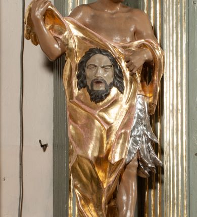 Zdjęcie nr 22: Ołtarz jednoosiowy, jednokondygnacyjny ze zwieńczeniem. Podwójny cokół z wąską, drewnianą mensą ołtarzową, wybrzuszoną. Na niej stoi tabernakulum ujęte kolumienkami i spływami wolutowymi, zwieńczone dwoma zwróconymi do siebie naczółkami z niewielką figurą baranka na tle promieni. Retabulum flankowane dwiema ćwierć kolumnami skierowanymi po ukosie na zewnątrz, z których każda ujęta parą korynckich, kanelowanych pilastrów dźwigających przełamujące się nad nimi belkowanie i dwa faliste naczółki. Na tle pilastrów, na konsolach stoją dwie figury egzotycznych mężczyzn. Zwieńczenie ujęte spływami wolutowymi, zakończone profilowanym, lekko falistym gzymsem z dwiema stykającymi się wolutami. W polu głównym szeroka, złocona, prostokątna rama z obrazem "Męczeństwo św. Bartłomieja", w zwieńczeniu owalny obraz w złoconej ramie z przedstawieniem Anioła Stróża. 
Figury egzotycznych (o typach wschodnich) mężczyzn ukazane w kontrapoście, o prawidłowych proporcjach ciała, z rękami uniesionymi przed siebie, na wysokości klatki piersiowej. Ich twarze są pełne, okrągłe o szerokich nosach i wydatnych, lekko otwartych ustach, na głowie krótkie, kręcone, ciemne włosy przytrzymane na czole złoconymi opaskami. Biodra okalają sięgające kolan spódniczki ze srebrnych piór. Mężczyzna po lewej stronie trzyma skórę z twarzą św. Bartłomieja osłaniającą część jego ciała, a postać po prawej nosi na plechach płaszcz sięgający stóp. Na dekorację ornamentalną składają się drobne motywy roślinne, kampanule na ćwierćkolumnach, kartusz ujęty drobnymi rocaille’ami, zwisy róż i gałązek palm wokół obrazu w zwieńczeniu i efektowna podwójna muszla palmetowa w zwieńczeniu. 
