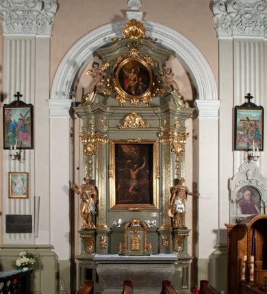 Zdjęcie nr 1: Ołtarz jednoosiowy, jednokondygnacyjny ze zwieńczeniem. Podwójny cokół z wąską, drewnianą mensą ołtarzową, wybrzuszoną. Na niej stoi tabernakulum ujęte kolumienkami i spływami wolutowymi, zwieńczone dwoma zwróconymi do siebie naczółkami z niewielką figurą baranka na tle promieni. Retabulum flankowane dwiema ćwierć kolumnami skierowanymi po ukosie na zewnątrz, z których każda ujęta parą korynckich, kanelowanych pilastrów dźwigających przełamujące się nad nimi belkowanie i dwa faliste naczółki. Na tle pilastrów, na konsolach stoją dwie figury egzotycznych mężczyzn. Zwieńczenie ujęte spływami wolutowymi, zakończone profilowanym, lekko falistym gzymsem z dwiema stykającymi się wolutami. W polu głównym szeroka, złocona, prostokątna rama z obrazem "Męczeństwo św. Bartłomieja", w zwieńczeniu owalny obraz w złoconej ramie z przedstawieniem Anioła Stróża. 
Figury egzotycznych (o typach wschodnich) mężczyzn ukazane w kontrapoście, o prawidłowych proporcjach ciała, z rękami uniesionymi przed siebie, na wysokości klatki piersiowej. Ich twarze są pełne, okrągłe o szerokich nosach i wydatnych, lekko otwartych ustach, na głowie krótkie, kręcone, ciemne włosy przytrzymane na czole złoconymi opaskami. Biodra okalają sięgające kolan spódniczki ze srebrnych piór. Mężczyzna po lewej stronie trzyma skórę z twarzą św. Bartłomieja osłaniającą część jego ciała, a postać po prawej nosi na plechach płaszcz sięgający stóp. Na dekorację ornamentalną składają się drobne motywy roślinne, kampanule na ćwierćkolumnach, kartusz ujęty drobnymi rocaille’ami, zwisy róż i gałązek palm wokół obrazu w zwieńczeniu i efektowna podwójna muszla palmetowa w zwieńczeniu. 
