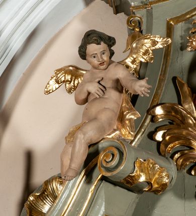 Zdjęcie nr 7: Ołtarz jednoosiowy, jednokondygnacyjny ze zwieńczeniem. Podwójny cokół z wąską, drewnianą mensą ołtarzową, wybrzuszoną. Na niej stoi tabernakulum ujęte kolumienkami i spływami wolutowymi, zwieńczone dwoma zwróconymi do siebie naczółkami z niewielką figurą baranka na tle promieni. Retabulum flankowane dwiema ćwierć kolumnami skierowanymi po ukosie na zewnątrz, z których każda ujęta parą korynckich, kanelowanych pilastrów dźwigających przełamujące się nad nimi belkowanie i dwa faliste naczółki. Na tle pilastrów, na konsolach stoją dwie figury egzotycznych mężczyzn. Zwieńczenie ujęte spływami wolutowymi, zakończone profilowanym, lekko falistym gzymsem z dwiema stykającymi się wolutami. W polu głównym szeroka, złocona, prostokątna rama z obrazem "Męczeństwo św. Bartłomieja", w zwieńczeniu owalny obraz w złoconej ramie z przedstawieniem Anioła Stróża. 
Figury egzotycznych (o typach wschodnich) mężczyzn ukazane w kontrapoście, o prawidłowych proporcjach ciała, z rękami uniesionymi przed siebie, na wysokości klatki piersiowej. Ich twarze są pełne, okrągłe o szerokich nosach i wydatnych, lekko otwartych ustach, na głowie krótkie, kręcone, ciemne włosy przytrzymane na czole złoconymi opaskami. Biodra okalają sięgające kolan spódniczki ze srebrnych piór. Mężczyzna po lewej stronie trzyma skórę z twarzą św. Bartłomieja osłaniającą część jego ciała, a postać po prawej nosi na plechach płaszcz sięgający stóp. Na dekorację ornamentalną składają się drobne motywy roślinne, kampanule na ćwierćkolumnach, kartusz ujęty drobnymi rocaille’ami, zwisy róż i gałązek palm wokół obrazu w zwieńczeniu i efektowna podwójna muszla palmetowa w zwieńczeniu. 
