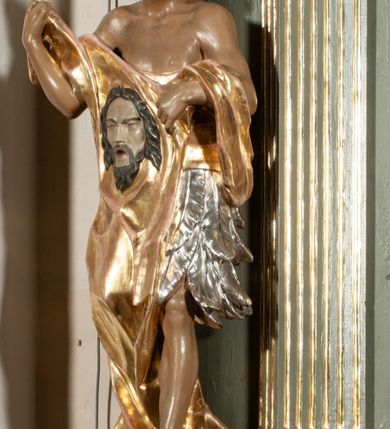 Zdjęcie nr 20: Ołtarz jednoosiowy, jednokondygnacyjny ze zwieńczeniem. Podwójny cokół z wąską, drewnianą mensą ołtarzową, wybrzuszoną. Na niej stoi tabernakulum ujęte kolumienkami i spływami wolutowymi, zwieńczone dwoma zwróconymi do siebie naczółkami z niewielką figurą baranka na tle promieni. Retabulum flankowane dwiema ćwierć kolumnami skierowanymi po ukosie na zewnątrz, z których każda ujęta parą korynckich, kanelowanych pilastrów dźwigających przełamujące się nad nimi belkowanie i dwa faliste naczółki. Na tle pilastrów, na konsolach stoją dwie figury egzotycznych mężczyzn. Zwieńczenie ujęte spływami wolutowymi, zakończone profilowanym, lekko falistym gzymsem z dwiema stykającymi się wolutami. W polu głównym szeroka, złocona, prostokątna rama z obrazem "Męczeństwo św. Bartłomieja", w zwieńczeniu owalny obraz w złoconej ramie z przedstawieniem Anioła Stróża. 
Figury egzotycznych (o typach wschodnich) mężczyzn ukazane w kontrapoście, o prawidłowych proporcjach ciała, z rękami uniesionymi przed siebie, na wysokości klatki piersiowej. Ich twarze są pełne, okrągłe o szerokich nosach i wydatnych, lekko otwartych ustach, na głowie krótkie, kręcone, ciemne włosy przytrzymane na czole złoconymi opaskami. Biodra okalają sięgające kolan spódniczki ze srebrnych piór. Mężczyzna po lewej stronie trzyma skórę z twarzą św. Bartłomieja osłaniającą część jego ciała, a postać po prawej nosi na plechach płaszcz sięgający stóp. Na dekorację ornamentalną składają się drobne motywy roślinne, kampanule na ćwierćkolumnach, kartusz ujęty drobnymi rocaille’ami, zwisy róż i gałązek palm wokół obrazu w zwieńczeniu i efektowna podwójna muszla palmetowa w zwieńczeniu. 
