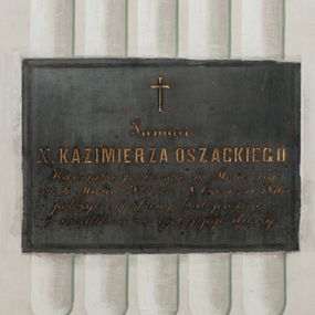 Zdjęcie nr 1: Epitafium w formie leżącego prostokąta z inskrypcją: "Pamięci / X(iędza) KAZIMIERZA OSZACKIEGO / Kanonika proboszcza w Morawicy / ur(odzonego) 4 Marca 1826 zm(arłego) 8 Czerwca 1876 r(oku) / położył stroskany brat prosząc / o modlitwę za spokój jego duszy." 