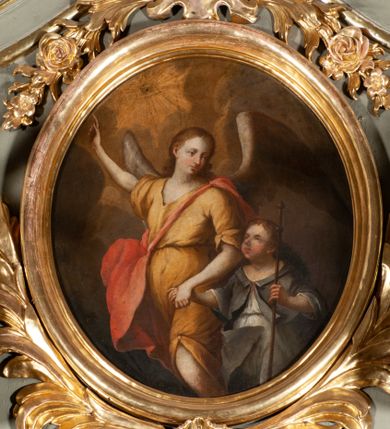 Zdjęcie nr 1: Owalny obraz ukazuje anioła prowadzącego za rękę chłopca. Anioł ukazany do kolan, w trzech czwartych, z prawą ręką uniesioną w kierunku przedstawionego na niebie oka Opatrzności i z lewą trzymającą za rękę chłopca. Jego twarz jest modelowana łagodnie, szkicowo, z otwartymi oczami, prostym nosem i drobnymi ustami oraz jasnymi włosami opadającymi na kark. Jest ubrany w żółtą suknię z trójkątnym dekoltem, krótkimi rękawami i z odsłoniętą lewą nogą oraz czerwony płaszcz przerzucony przez lewe ramię i zarzucony na plecy i prawe biodro. Za plecami widoczne są rozpostarte skrzydła. Chłopiec przedstawiony został do kolan, w trzech czwartych, w jasnej sukni i szarym płaszczu, z kijem pielgrzymim w lewej ręce. Jego twarz jest okrągła, pełna, z zaczerwionymi policzkami, oczy małe, otwarte, nos krótki, usta drobne. Tło ciemne, nieokreślone. 
