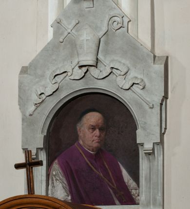 Zdjęcie nr 1: Epitafium w kształcie aediculi z półkolistą arkadą z portretem zmarłego i tablicą z inskrypcją poniżej. Arkada zwieńczona daszkiem portalowym, na którym infuła z karbowanymi taśmami i krzyżem oraz skrzyżowanymi za nią krzyżem i pastorałem. Duchowny przedstawiony w półpostaci, w trzech czwartych, w lewo. Twarz oddana realistycznie, o prostych rysach, z oczami zwróconymi na wprost, długim nosie, wyrazistych, zaciśniętych ustach, z odsłoniętą łysiną i czarną piuską na głowie. Ubrany w komżę i fioletowy mantolet. Na tablicy u dołu częściowo wypukłorzeźbiona, a częściowo ryta inskrypcja:  "D(EO) O(PTIMO) M(AXIMO) / KS(IĄDZ) JÓZEF KRZEMIEŃSKI / PRAŁAT DOM(OWY) OJCA Ś(więte)go KANONIK H(ONOROWY) WARSZAWSKI / ARCHIPREZBYTER KOŚCIOŁA N(AJŚWIĘTSZEJ) P(ANNY) MARYI / URODZONY w KRAKOWIE 1835 ZMARŁ w r(oku) 1912 / B(YŁY) PROBOSZCZ W MORAWICY. / PROSI O WESTCHNIENIE DO BOGA!"  