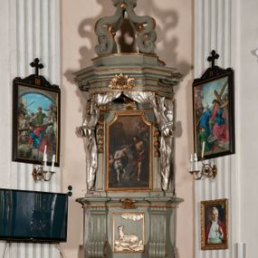 Zdjęcie nr 1: Antyambona składa się z wysokiego cokołu ujętego  szerokimi, kanelowanymi spływami wolutowymi i figurą baranka, zaplecka z obrazem ukazującym chrzest Chrystusa w Jordanie, ujętego podwieszoną kotarą i baldachim z podwieszoną pod nim kotarą. Na nim cztery esowato wygięte i łączące się górą ze sobą kabłąki, zakończone personifikacją Kościoła – kobiety w tiarze papieskiej na głowie. 