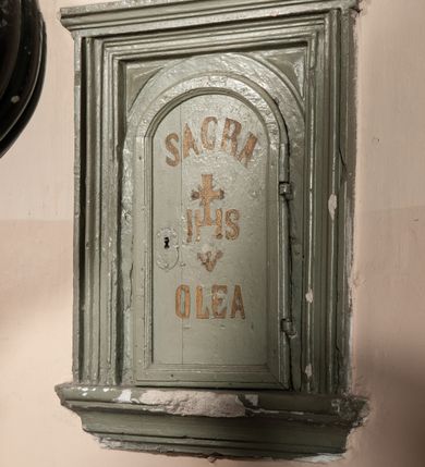 Zdjęcie nr 4: Podstawa okrągła, dwustopniowa z prostopadłościenną górną częścią, z trzonem w typie gruszkowatym z wałkiem w górnej części, podtrzymującym czarę w formie spłaszczonej kuli z puklami. Na czarze tarcza herbowa ujęta wolutami z godłem herbu Szaszor lub Orla. Pokrywa drewniana, w kształcie smukłej półkopuły o powierzchni pokrytej srebrzonymi łuskami, obwiedzionej koroną, podzielona żebrami z żabkami i zwieńczona koroną. Nad kopułą sześcioboczna wieżyczka ujęta wolnostojącymi pinaklami. Jej ścianki zakończone trójkątnie z ornamentalnymi grzebieniami, wypełnione wnękami z postaciami aniołów. Nad wieżyczką figura św. Jana Chrzciciela, ubranego w wielbłądzią skórę i płaszcz przerzucony na prawym ramieniu. W prawej dłoni podtrzymuje baranka, w lewej trzyma osadzony na długim trzpieniu krzyż. Na wewnętrznej stronie pokrywy tabliczka z inskrypcją: „CURA ET IMPENSIS / JOSEPHI PAJĄCZEWSKI / CURATI MORAVICEAEN ET / DECANI CZERNICHOVIEN A(NNO) D(OMINI) 1904 A(D) M(AIOREM) D(EI) G(LORIAM)”.        