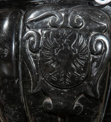 Zdjęcie nr 6: Podstawa okrągła, dwustopniowa z prostopadłościenną górną częścią, z trzonem w typie gruszkowatym z wałkiem w górnej części, podtrzymującym czarę w formie spłaszczonej kuli z puklami. Na czarze tarcza herbowa ujęta wolutami z godłem herbu Szaszor lub Orla. Pokrywa drewniana, w kształcie smukłej półkopuły o powierzchni pokrytej srebrzonymi łuskami, obwiedzionej koroną, podzielona żebrami z żabkami i zwieńczona koroną. Nad kopułą sześcioboczna wieżyczka ujęta wolnostojącymi pinaklami. Jej ścianki zakończone trójkątnie z ornamentalnymi grzebieniami, wypełnione wnękami z postaciami aniołów. Nad wieżyczką figura św. Jana Chrzciciela, ubranego w wielbłądzią skórę i płaszcz przerzucony na prawym ramieniu. W prawej dłoni podtrzymuje baranka, w lewej trzyma osadzony na długim trzpieniu krzyż. Na wewnętrznej stronie pokrywy tabliczka z inskrypcją: „CURA ET IMPENSIS / JOSEPHI PAJĄCZEWSKI / CURATI MORAVICEAEN ET / DECANI CZERNICHOVIEN A(NNO) D(OMINI) 1904 A(D) M(AIOREM) D(EI) G(LORIAM)”.        