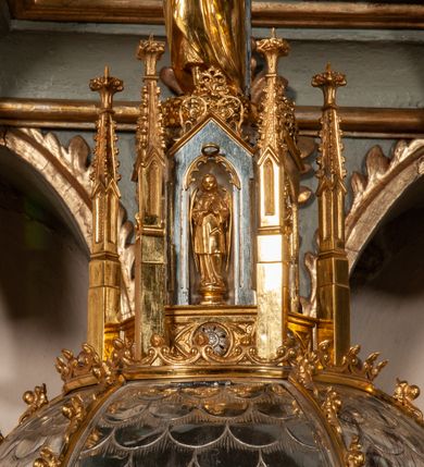 Zdjęcie nr 9: Podstawa okrągła, dwustopniowa z prostopadłościenną górną częścią, z trzonem w typie gruszkowatym z wałkiem w górnej części, podtrzymującym czarę w formie spłaszczonej kuli z puklami. Na czarze tarcza herbowa ujęta wolutami z godłem herbu Szaszor lub Orla. Pokrywa drewniana, w kształcie smukłej półkopuły o powierzchni pokrytej srebrzonymi łuskami, obwiedzionej koroną, podzielona żebrami z żabkami i zwieńczona koroną. Nad kopułą sześcioboczna wieżyczka ujęta wolnostojącymi pinaklami. Jej ścianki zakończone trójkątnie z ornamentalnymi grzebieniami, wypełnione wnękami z postaciami aniołów. Nad wieżyczką figura św. Jana Chrzciciela, ubranego w wielbłądzią skórę i płaszcz przerzucony na prawym ramieniu. W prawej dłoni podtrzymuje baranka, w lewej trzyma osadzony na długim trzpieniu krzyż. Na wewnętrznej stronie pokrywy tabliczka z inskrypcją: „CURA ET IMPENSIS / JOSEPHI PAJĄCZEWSKI / CURATI MORAVICEAEN ET / DECANI CZERNICHOVIEN A(NNO) D(OMINI) 1904 A(D) M(AIOREM) D(EI) G(LORIAM)”.        