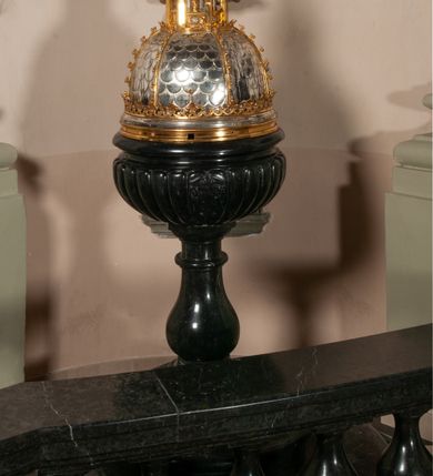 Zdjęcie nr 2: Podstawa okrągła, dwustopniowa z prostopadłościenną górną częścią, z trzonem w typie gruszkowatym z wałkiem w górnej części, podtrzymującym czarę w formie spłaszczonej kuli z puklami. Na czarze tarcza herbowa ujęta wolutami z godłem herbu Szaszor lub Orla. Pokrywa drewniana, w kształcie smukłej półkopuły o powierzchni pokrytej srebrzonymi łuskami, obwiedzionej koroną, podzielona żebrami z żabkami i zwieńczona koroną. Nad kopułą sześcioboczna wieżyczka ujęta wolnostojącymi pinaklami. Jej ścianki zakończone trójkątnie z ornamentalnymi grzebieniami, wypełnione wnękami z postaciami aniołów. Nad wieżyczką figura św. Jana Chrzciciela, ubranego w wielbłądzią skórę i płaszcz przerzucony na prawym ramieniu. W prawej dłoni podtrzymuje baranka, w lewej trzyma osadzony na długim trzpieniu krzyż. Na wewnętrznej stronie pokrywy tabliczka z inskrypcją: „CURA ET IMPENSIS / JOSEPHI PAJĄCZEWSKI / CURATI MORAVICEAEN ET / DECANI CZERNICHOVIEN A(NNO) D(OMINI) 1904 A(D) M(AIOREM) D(EI) G(LORIAM)”.        